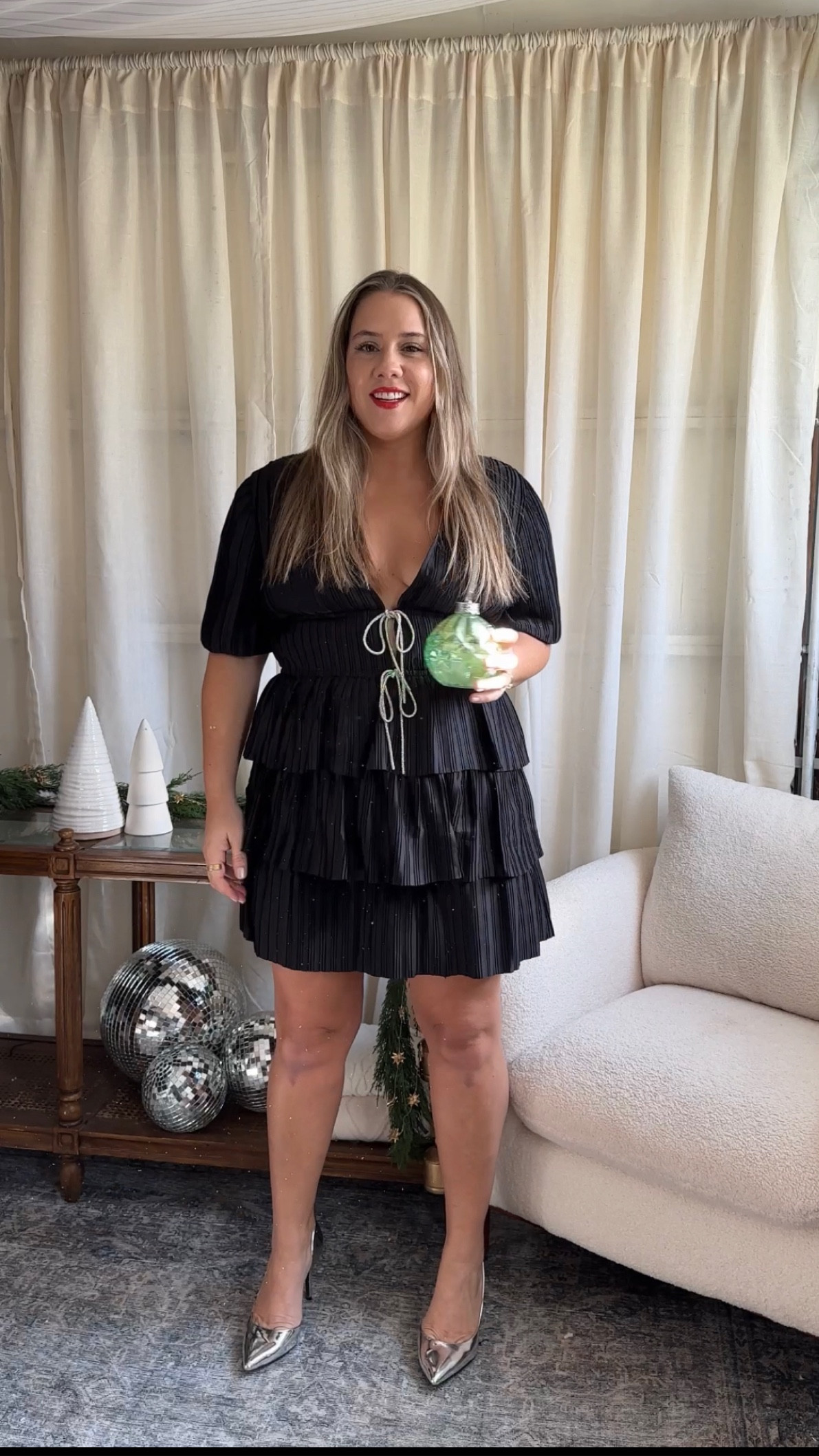 This is such a fun holiday dress! Perfect for date night or parties. Go with your regular dress size.

Im in a medium- would prefer the large overall. 

Tiers arent stretchy but fall really nicely! 

There is one toggle looped button under the first rhinestone bow. 

Use fashion tape to secure deep V if needed. Im wearing just cakes covers here. 

#LTKfindsunder100 #LTKmidsize

#LTKHoliday