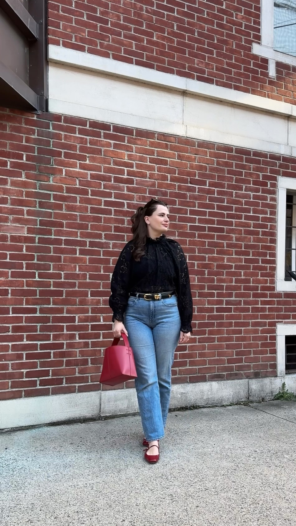 A cool and effortless take on spring dressing with a black lace top, straight-leg light wash jeans, and pops of cherry red with the leather bag and matching flats. The monochrome base with statement accessories keeps it timeless and chic.