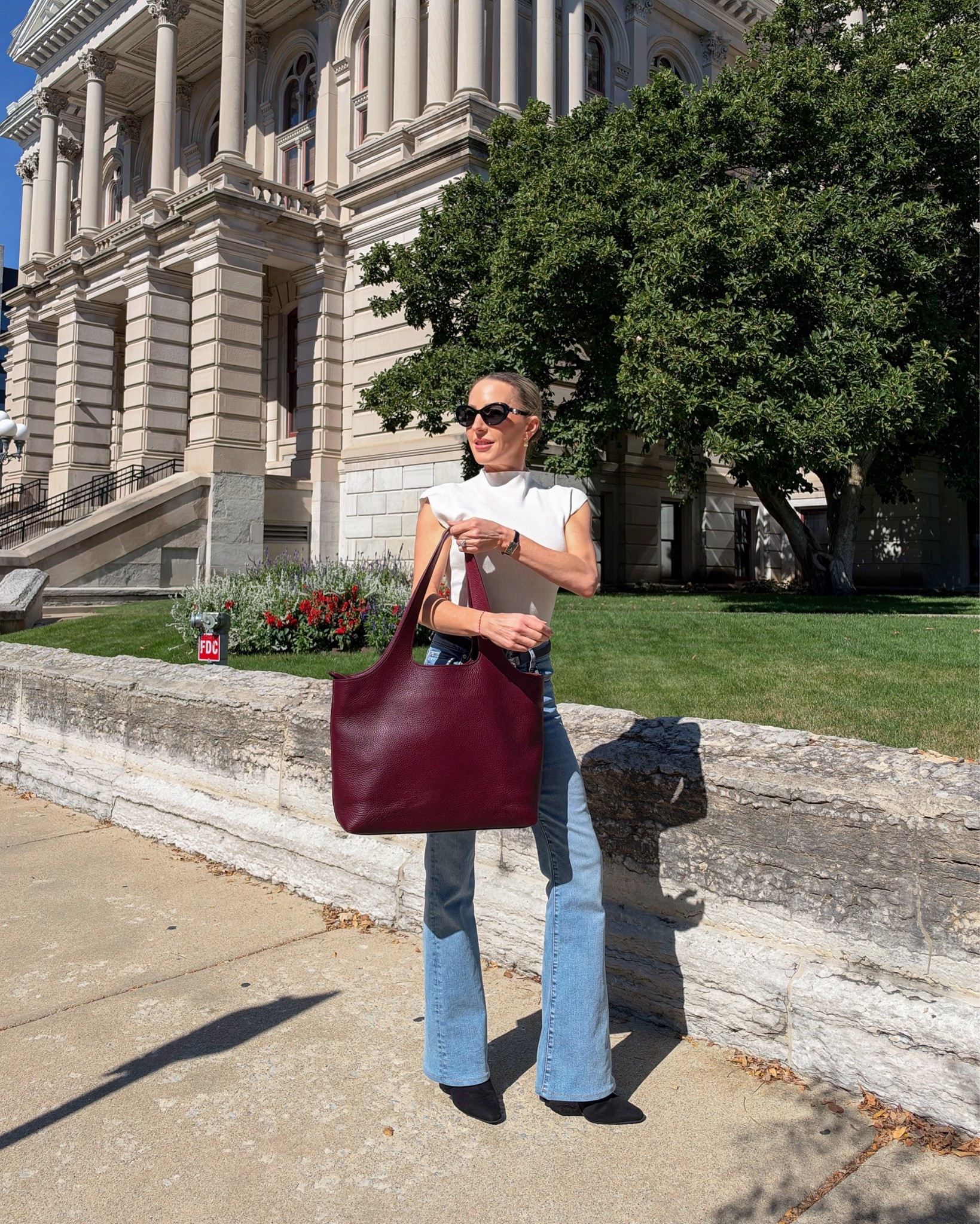 Fall outfit: wide leg jeans, white knit cap sleeve top, black suede boots and burgundy leather tote bag 🍂 Wearing as XS in the white turtleneck which runs TTS in my opinion.