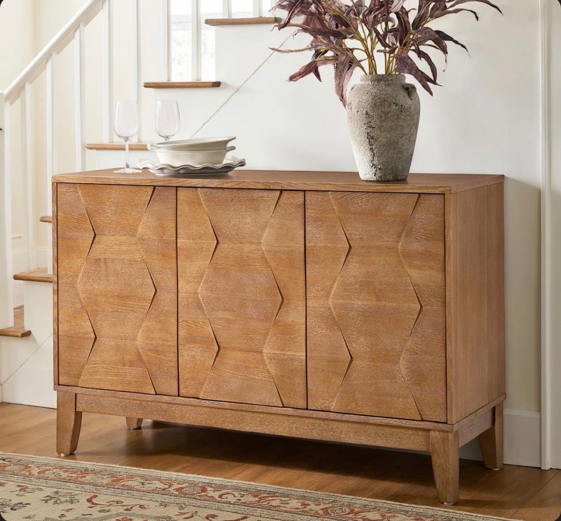 This sideboard from Wayfair makes a style statement with its textured design and mid-century vibe. The clean-lined frame is made from solid and engineered wood, and it rests on four tapered legs that keep sightlines clear. The three-door fronts feature captivating hexagonal embellishments, adding subtle visual texture and dimension to the overall design. And there's plenty of room inside for all your daily essentials. Plus, the spacious surface is great as a coffee or dessert station during holiday parties and get-togethers. Hand-curated by Kelly Clarkson

#LTKHome #LTKSeasonal