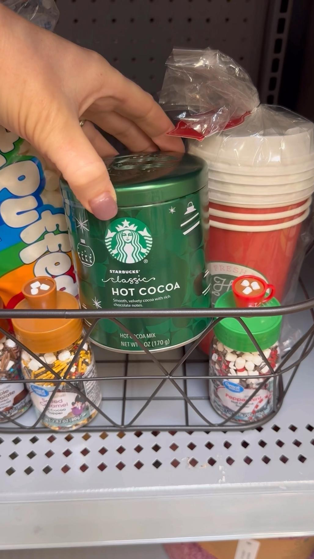 DIY Hot Cocoa Holiday basket. I added Hot cocoa mix, hot chocolate toppings, mini marshmallows, disposable coffee cups and put it all in a basket. The entire gift is less than $30. #Hotcocagiftbasket #DIYgiftbasket #giftidea #DIYgift #hotchocolatebasket 

#LTKGiftGuide #LTKHoliday #LTKSeasonal