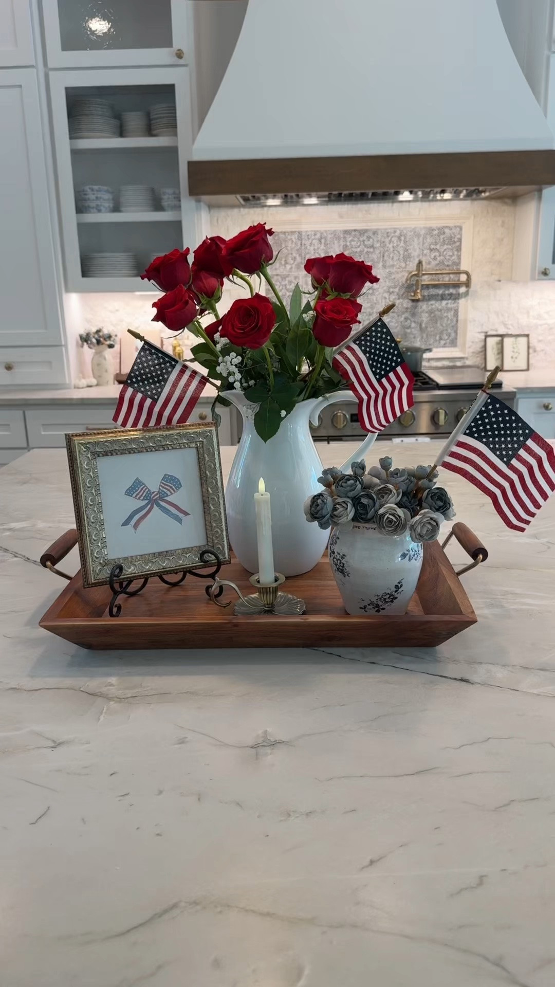 Another Memorial Day or 4th of July centerpiece idea🇺🇸 I love the red roses  paired with the blue ranunculus!  I also love the picture has a vintage feel paired along with the antiqued candleholder for a beautiful glow! The American flags are the perfect added touch to really bring out the patriotism of this tray styling🤍

#mdw #4thofJuly #redwhiteandblue #fourthofjuly #centerpiece

#LTKHome #LTKSeasonal #LTKvlog