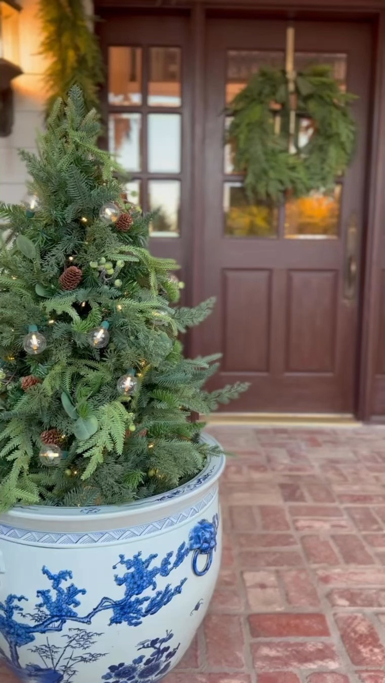 Find your outdoor holiday style, and spread cheer to the whole neighborhood with a wonderland of outdoor Christmas decorations at @frontgate. This year we opted to take a natural approach to our outdoor decor. 
We found the most gorgeous garlands and wreaths from @frontgatedallas. Adorning the doors and windows are the Norfolk pine garlands, layered for a magically natural look. The matching wreath with ribbon and bells is so elegant. 
It wouldn’t be an Eleven Gables Christmas without blue and white.💙🤍 Fill a Ming planter with this gorgeous Majestic holiday pre-lit and battery operated potted tree. 
Investing in quality Christmas decor from Frontgate elevates the overall ambiance and creates a memorable holiday experience for you and your loved ones. 
#holidayideas #holidayinspiration #frontporch #christmasporch #frontgate

#LTKHoliday #LTKCyberWeek #LTKSeasonal