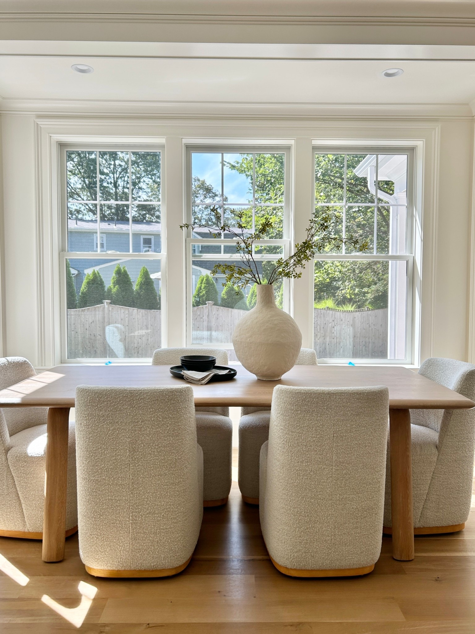 Breakfast nook.  88” light wood table with rounded edges paired with cream boucle chairs on castors. 

#diningtable #diningchairs 

#LTKHome