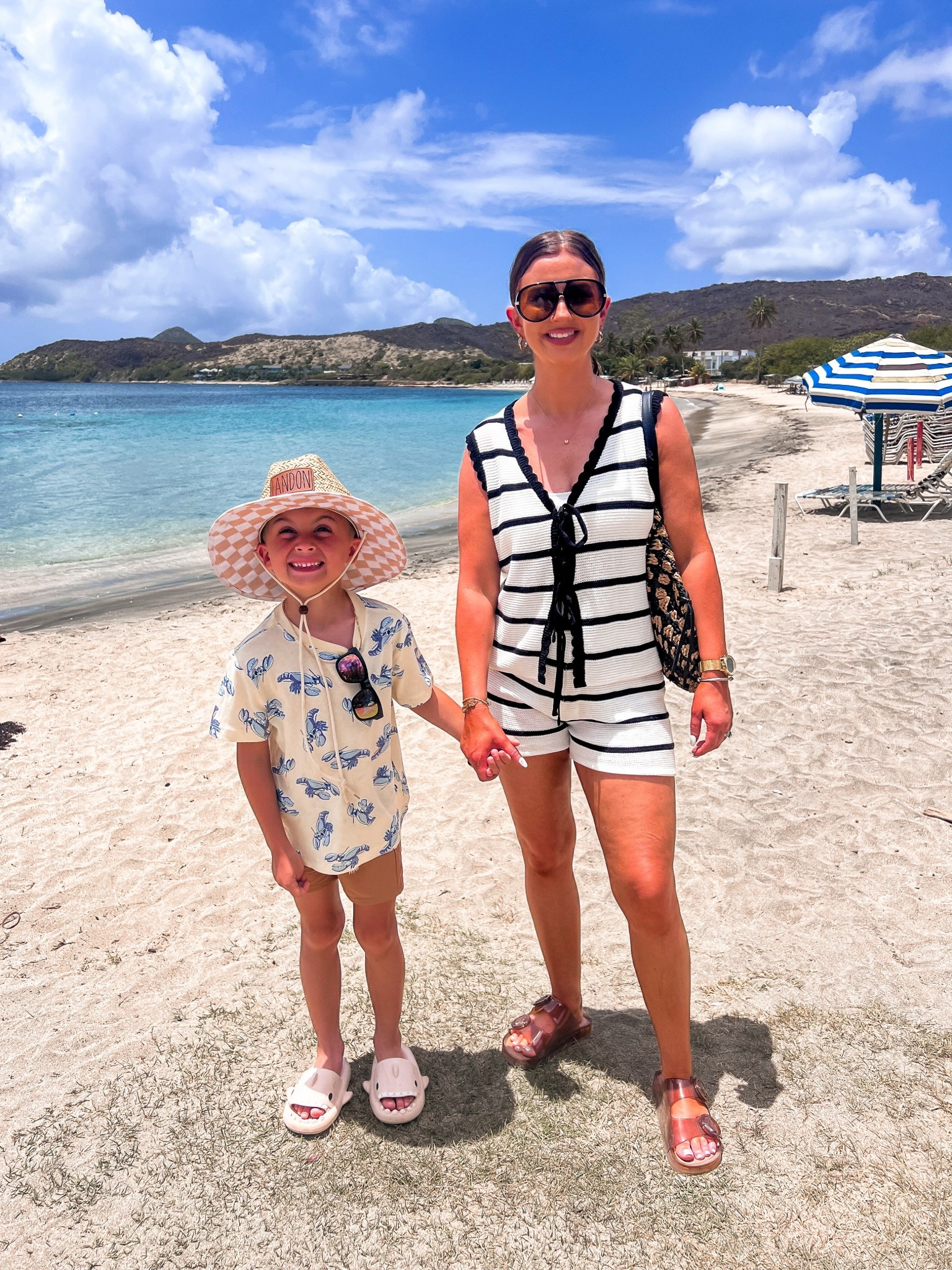 Black and white striped crochet shorts set
Black and gold aviator sunglasses 
Brown jelly sandals
Boys blue lobster summer tee shirt
Kids wide brim beach hat 
Kids plastic shark sandals