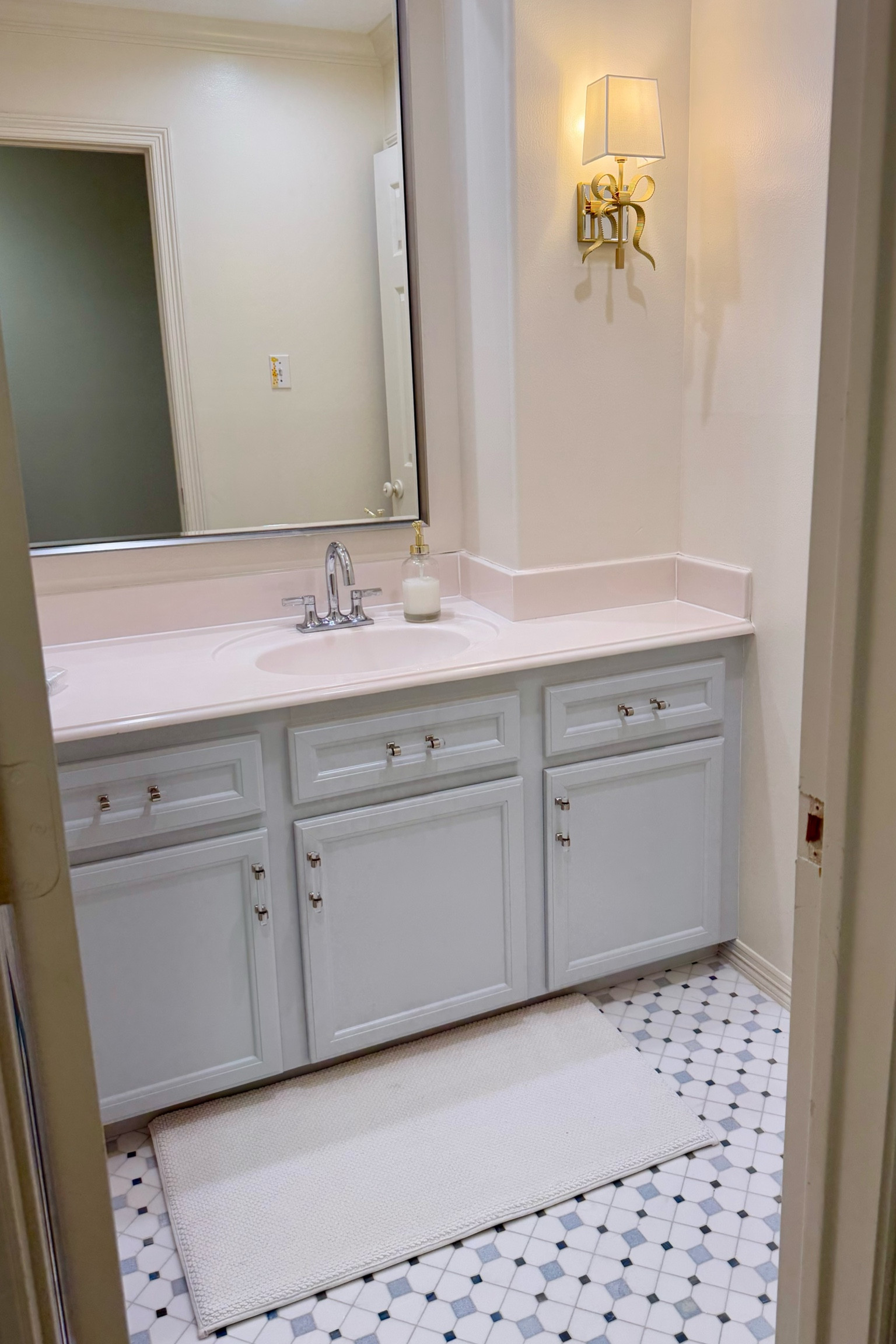 Absolutely love how this bathroom remodel turned out! The bow sconce and the mixed metal chrome cabinet pulls are my favorite detail

#LTKFamily #LTKStyleTip #LTKHome