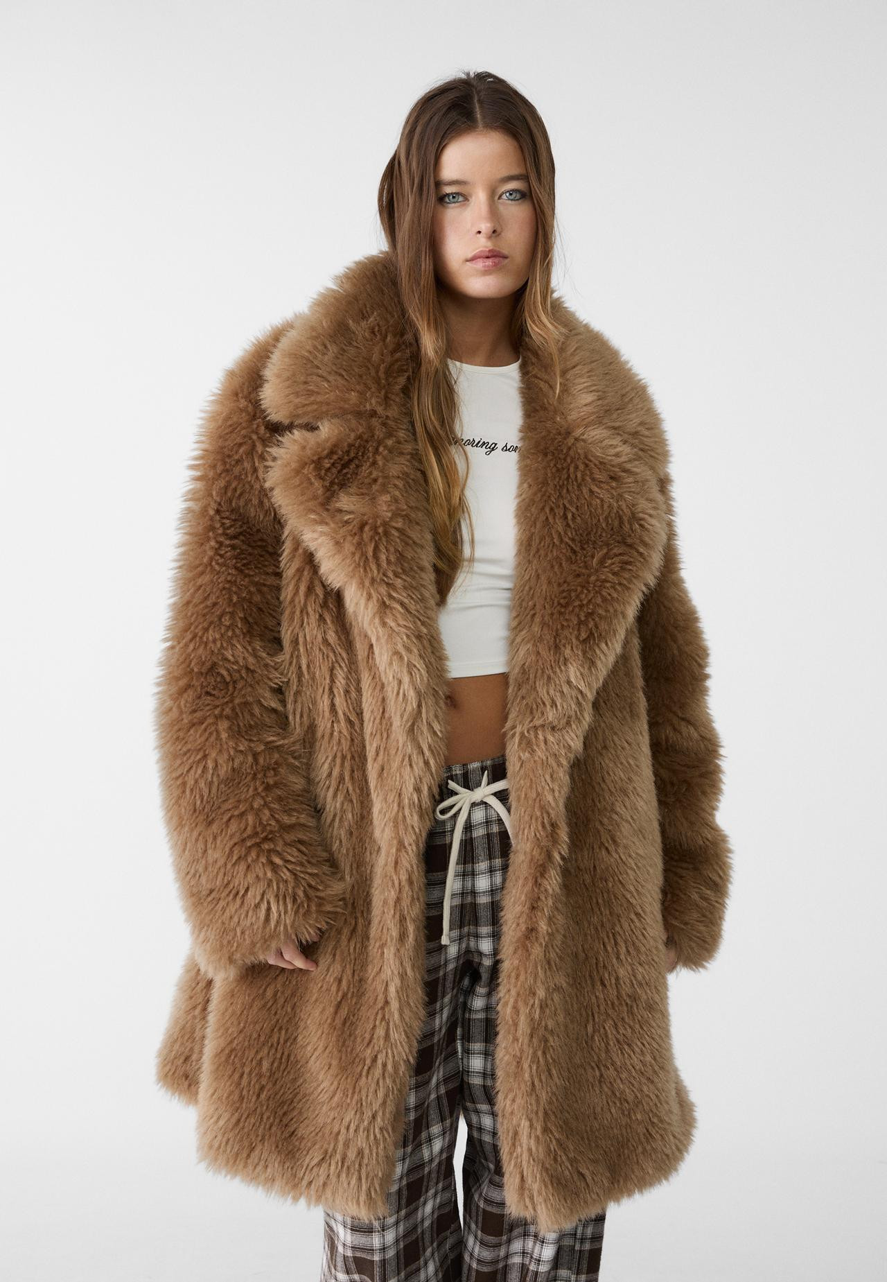 Long coat made of soft-touch faux fur. Featuring a lapel collar, long sleeves, side pockets and d... | Stradivarius (UK)