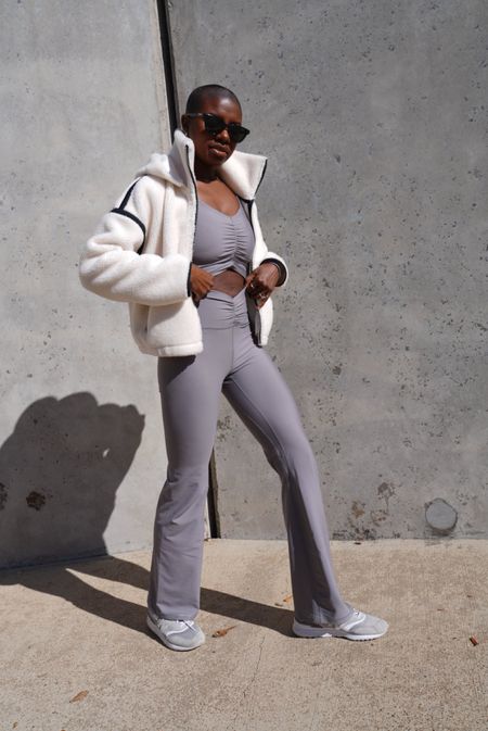 Grey workout set! Long sleeve ruched top, grey v waist flare leggings, grey retro new balance sneakers, cream Sherpa full zip jacket with detachable hoodie and black sunglasses  

#LTKfindsunder50 #LTKfindsunder100 #LTKfitness