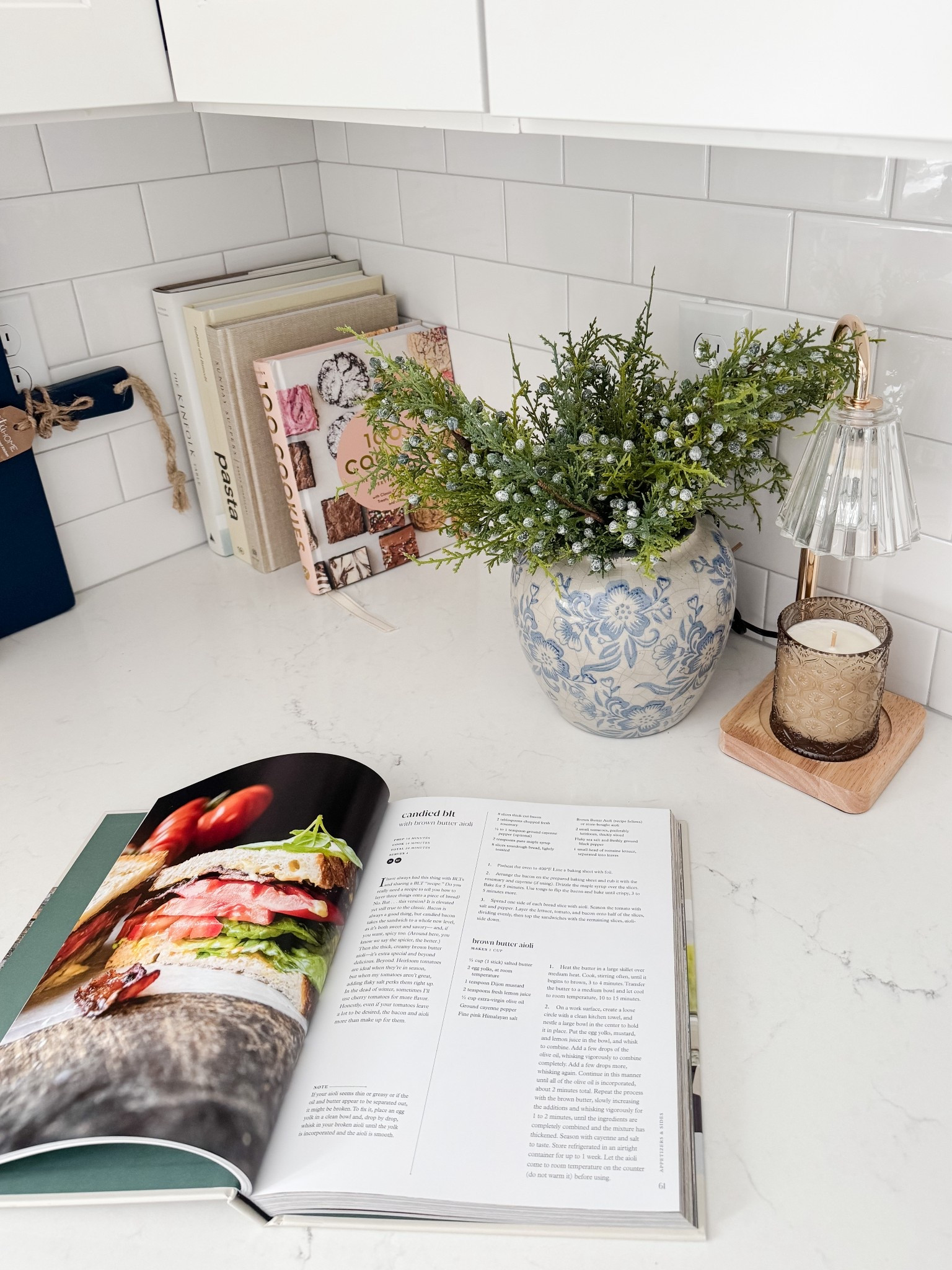 Cozy kitchen counter moment. This kitchen counter setup proves that simple details like cookbooks, greenery, and warm lighting can make everyday spaces feel welcoming.

Coastal kitchen decor, neutral kitchen, blue and white accents, cozy home details, simple styling, cape cod kitchen, everyday home inspiration, timeless design, Sherri calnan home

#LTKFindsUnder50 #LTKHome