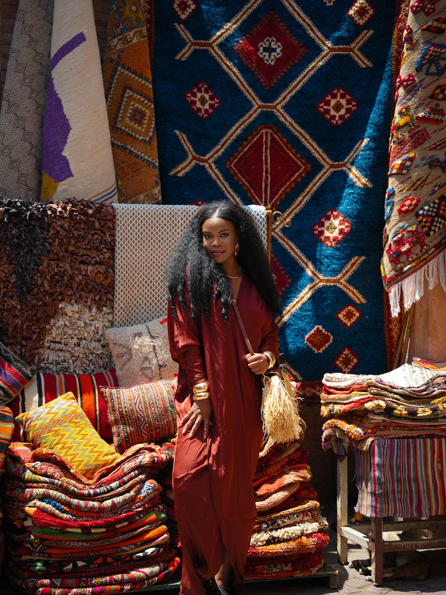 🇲🇦 By the end of my stay in the Marrakesh Medina, I had 1 purse, 2 poufs, 2 pillows, perfumes, 2 cups, 3 magnets, 1 painting, and 1 scarf lol. I came to Morocco ready with an almost empty checked bag. 

Other popular tourist souvenirs include jewelry, rugs, leather, dresses, dishes, tea sets, etc, but you can find almost anything inside the Medina. Plan to spend 2 to 3 days if you want enough time to shop deep and get familiar with the market.

Keep in mind that very few things are sold at a fixed price. A good rule of thumb is to start negotiating at about 30-40% of the asking price, compare offers between shops, and remember that market prices can also vary by city, such as in Fez or Chefchaouen.

Portrait Photographers @rachid_photography | @marrakech_photoshoots 
Dress @andreaiyamah 
Bag @brandonblackwoodnyc

#LTKGiftGuide #LTKHoliday #LTKTravel