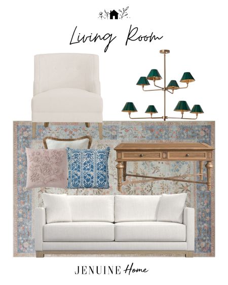 Light traditional living room. Green and gold chandelier. White traditional arm chair. White couch. Rifle Paper Co light blue and pink rug. Wooden coffee table. Blue throw pillow. Pink embroidery throw pillow. White and tassel throw pillow  