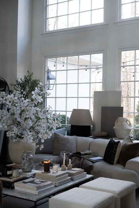 OMG this space makes me want to stay home forever. The tall windows, soft neutral layers, and cozy textures feel so calm and elevated. I am obsessed with the creamy sofa, stacked coffee table books, and fresh florals bringing everything to life. EEK this is that light filled, timeless home vibe I dream about every day.  

 #LTKSpringSale #LTKSeasonal #LTKHome