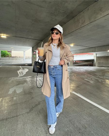 5/6/24 Rainy day outfit 🫶🏼 trench coat, trench coat outfit, Princess Polly jeans, dark wash denim, wide leg jeans, skims basics, skims long sleeve, skims tops, trucker hat outfit

