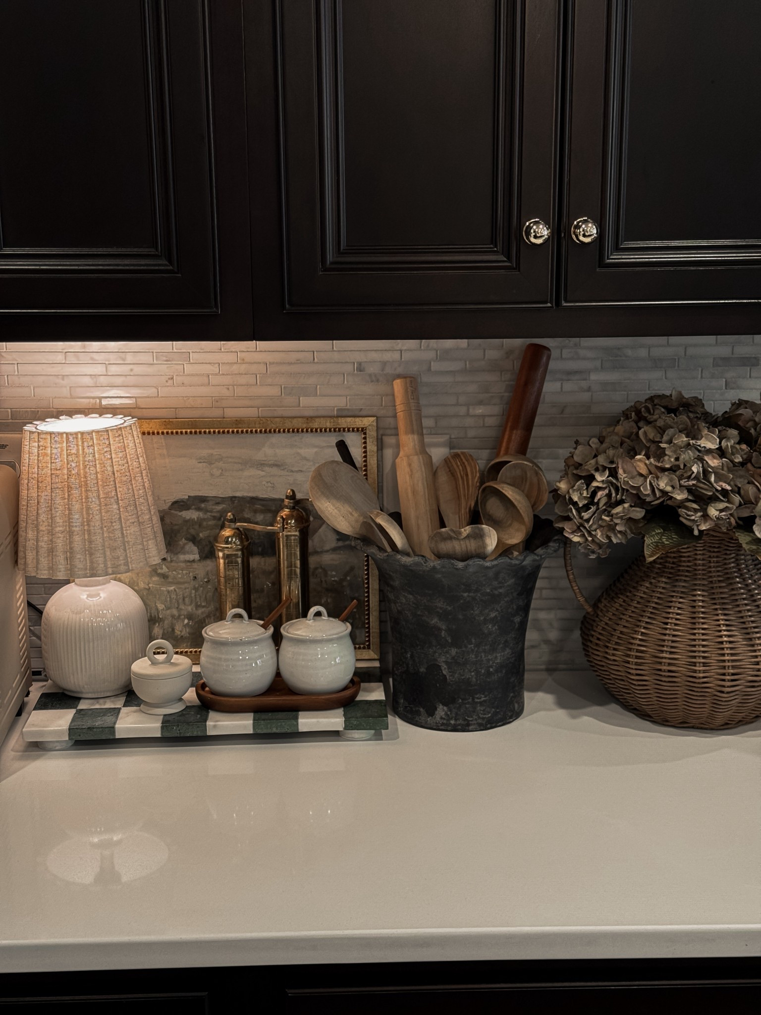 I wanted the counters to feel collected but still cozy and functional. I was inspired by my recent HomeGoods find—a green checkered marble tray that instantly elevated the space—and this gorgeous Pottery Barn planter I’m repurposing as a crock to hold all my favorite utensils. Mixing high and low pieces and adding just a few earthy elements helped everything come together so intentionally. Loving this little moment in the kitchen 🫶

Shop sources linked below 👇🏼

#kitchendecor #counterstyling #earthytouches #neutralhome #modernvintage #homegoodshome #potterybarnstyle #cozykitchen #livedinhome #howtohome #myhomesoul #organicvibes #collectedstyle #affordablehomedecor #kitchenmoments
