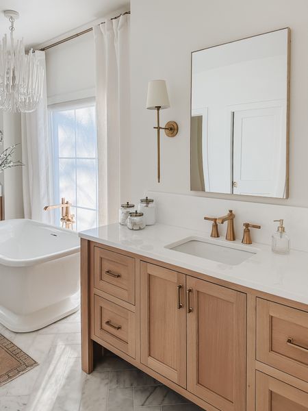 Bright and airy spring bathroom with neutral wood tones, creamy whites, and gold detail. Minimal design with small seasonal swaps for spring 

Bathroom views, light and bright, neutral wood tones, creamy whites, glass jar, faux linen curtain, bathtub detail, gold lighting, drawer pull, Pottery Barn style, bright and airy, soap dispenser, rug runner, Wayfair, Joss and Main, neutral home, aesthetic style, shop the look!

#LTKSeasonal #LTKhome #LTKsalealert