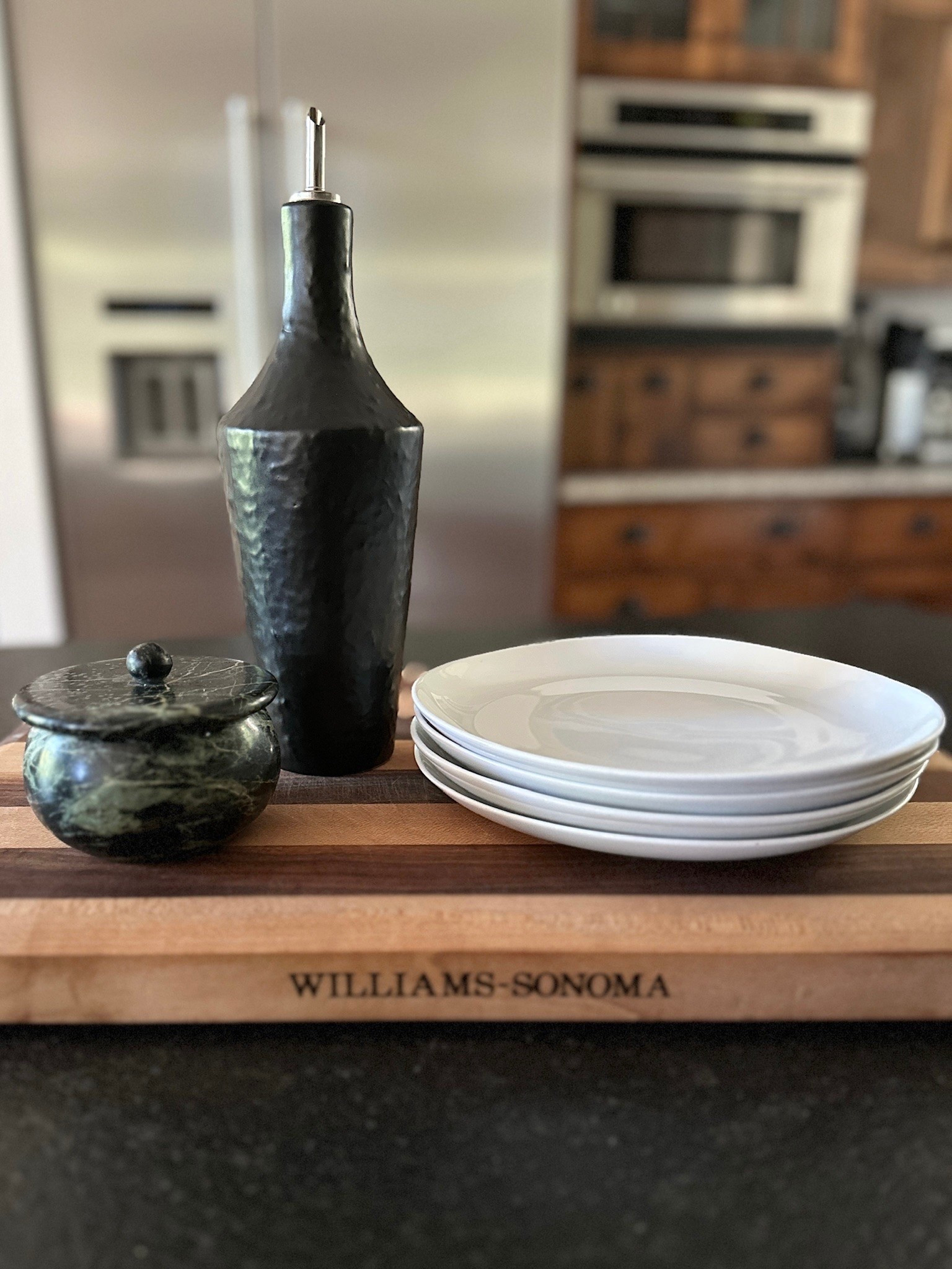 The counter styling trick that makes a kitchen feel finished. Keep the pretty everyday pieces out:  black oil dispenser, marble salt cellar, walnut cutting board, and simple white plates.

#LTKHome #LTKfoodie