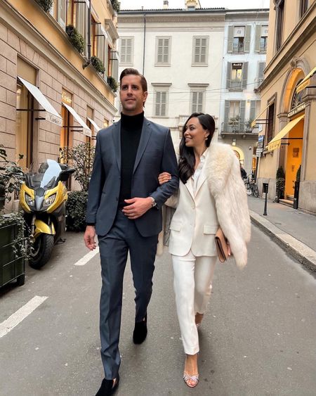 Kat Jamieson wears a white pantsuit in Milan. Thomas Jamieson wears a navy blue mens suit and velvet loafers. Holiday style, Christmas, his and hers outfits, couple, festive, cocktail party. 

#LTKHoliday #LTKmens #LTKSeasonal