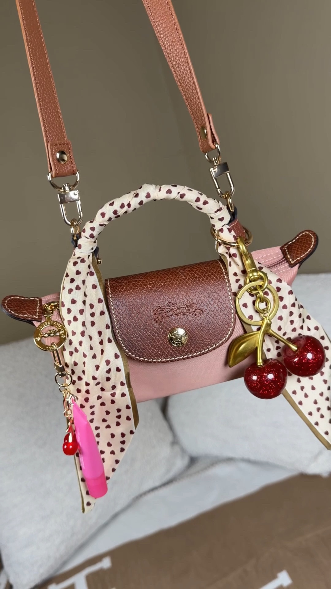 Valentine’s Day vibes with the pink Longchamp mini pouch 💗

Cherry bag charm
Cherry wallet card holder from Amazon
Lip gloss charm
Heart Twilly 
