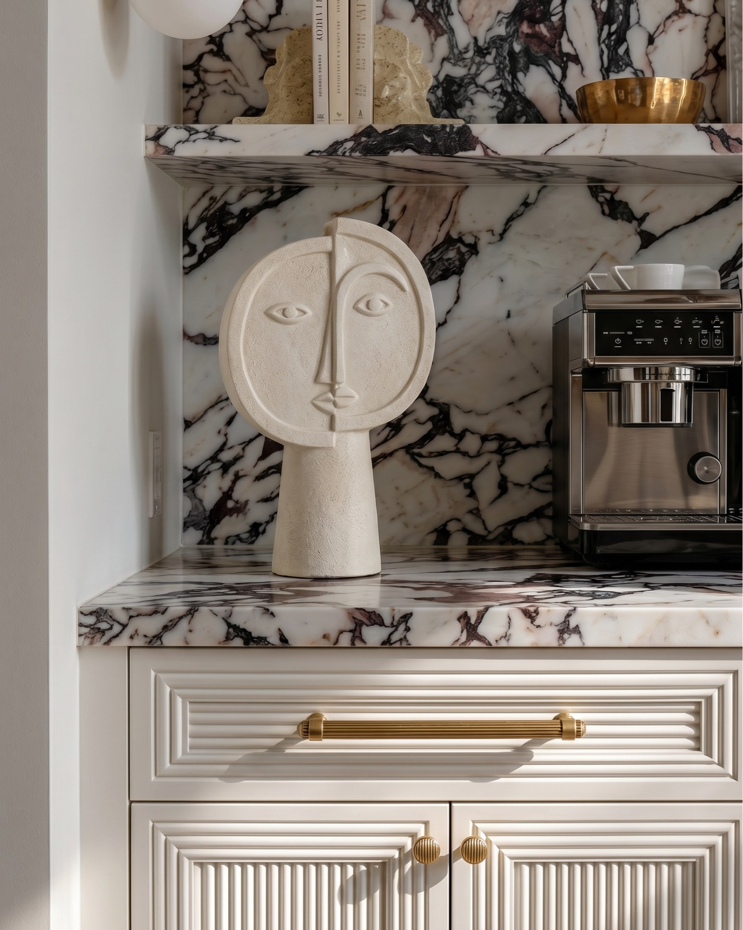 Shop the look:
• Fluted cream built-in cabinetry
• Brass cabinet hardware (pulls + knobs)
• Glass-front upper cabinet doors (reeded / ribbed glass)
• Brass dual globe wall sconces (white milk glass)
• Built-in wine fridge (glass door, brass trim)
• Espresso machine / built-in coffee station
• Decorative ceramic face sculpture
• Neutral ceramic bowls
• White ceramic pitcher
• Amber glass bottles
• Framed vintage artwork
• Decorative wood tray
• Brass bowl / catchall
• Sculptural woven vase
• Neutral decorative books
• Large woven or textured runner rug (taupe / beige)
• Light oak ceiling beams
• Light wood console table (minimal modern design)
• Upholstered round stools / vanity stools
• Neutral floral wallpaper (large-scale botanical print)
• Oversized abstract wall art (black frame)
• Brass double globe sconces
• Ceramic table lamp (neutral textured base)
• Gold sculptural ring decor
• Large rope detail ceramic vases
• Vintage-inspired neutral hallway runner
• Decorative wood bowls
• Ceramic decor accents
• Cream boucle accent chair
• Arched black-framed window
• Light gray upholstered wingback bed
• White bedding set (duvet + sheets)
• Chunky knit throw blanket (cream)
• Neutral accent pillows (textured + patterned)
• Upholstered bedroom bench (cream with brass legs)
• Light wood nightstands (3-drawer)
• Pleated table lamp (neutral ceramic base)
• Large glass vase with greenery / dried florals
• Ornate gold full-length mirrors
• Brass double globe wall sconces
• Large abstract artwork above bed
• White globe pendant light
• Vintage-inspired area rug (gray / beige)
• Light wood ceiling beams
• Soft linen curtains (cream)
• Herringbone hardwood flooring
• Small ceramic vase with dried florals
• Decorative bedside styling
• Neutral ceramic lamp
• Gold framed mirrors
• Minimal layered pillows
• Luxury hotel-style white duvet

#LTKsale #LTKhome