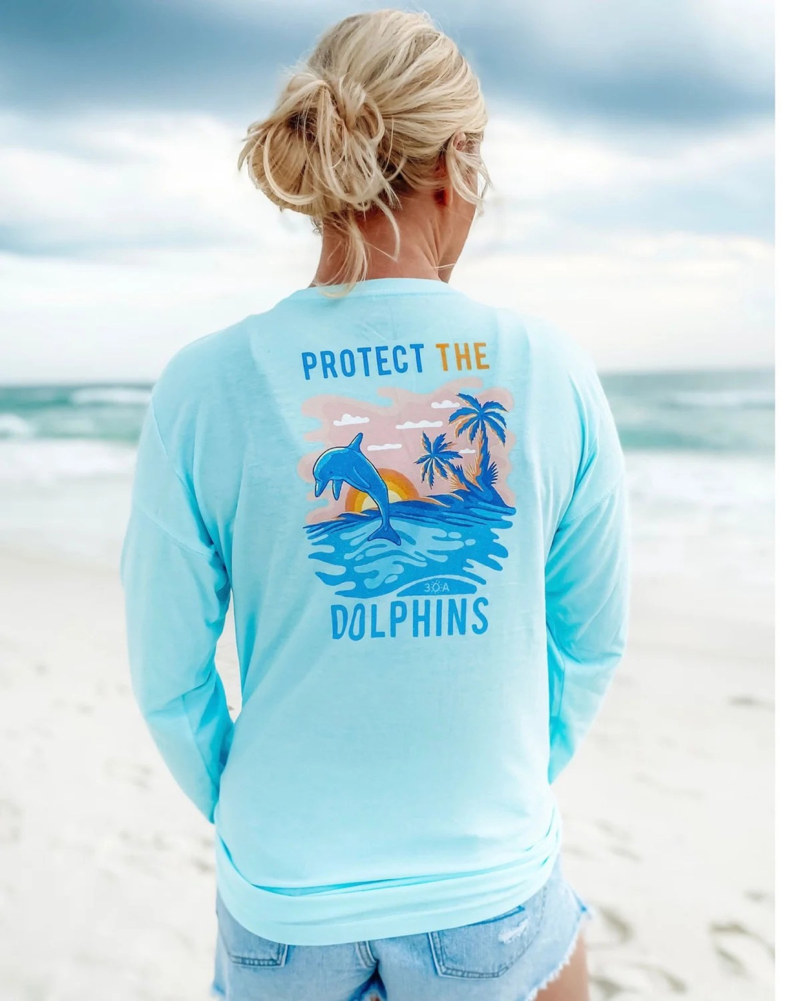 Protect The Dolphins Long Sleeve Tee- 
Women Aqua 
Made from recycled plastic bottles that could otherwise end up in our oceans. Every super soft 30A shirt saves about 8 plastic bottles from landfills They’re blended with cotton so they’re incredibly soft. 

#LTKstyletip #LTKswim #LTKFind