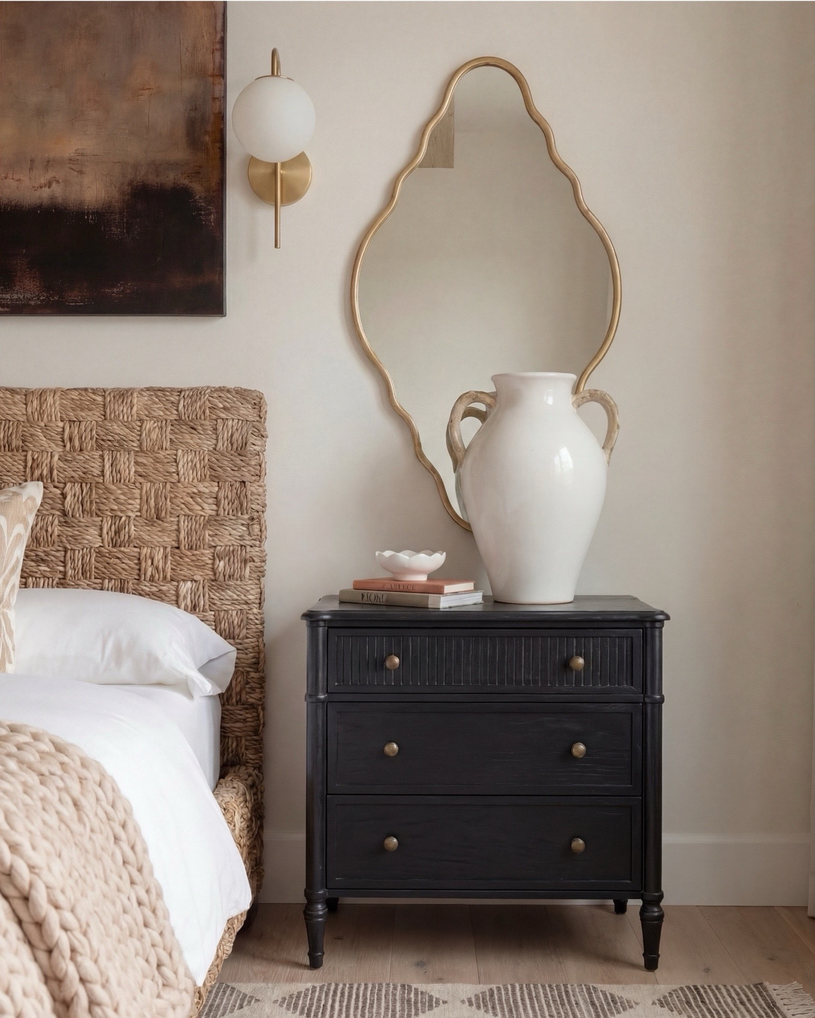 Shop the Look:
• Wood Woven rattan bed frame
• White upholstered mattress or box spring
• Black wood 3-drawer nightstands (set of 2)
• White duvet cover (hotel-style)
• White fitted sheet + pillow set
• Chunky knit throw blanket (beige or oatmeal)
• Neutral patterned accent pillow
• Brass globe wall sconces
• Cream ceramic table lamp with beige shade
• Large abstract landscape wall art (neutral tones)
•brown floral wall art
• Gold irregular curved scalloped wall mirrors
• Round woven knit poufs
• Neutral geometric or diamond area rug
• Large white ceramic vase
• Small decorative bowl (white or stone)
• Ivory linen curtain panels
•wood upholstered accent chair 
•black terracotta vase
•wood rattan dresser
•brass decor tray
•black leaf decor bowl 
•decor books

#LTKsale #LTKhome #LTKstyletip