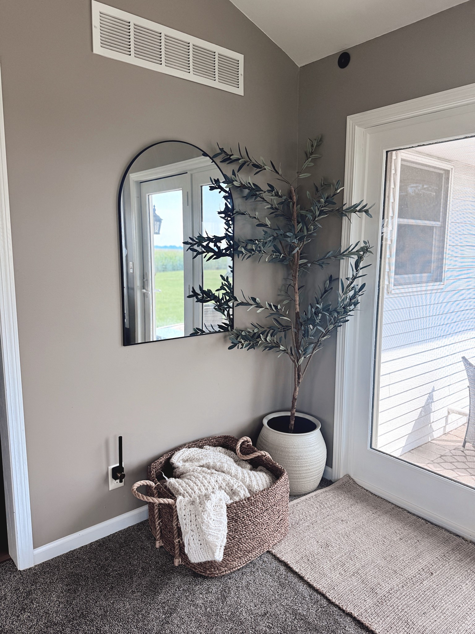 Cozy corner styling made simple ✨ This setup is all about layering: a statement mirror, a basket with throw blankets, and an olive tree to add height + greenery. Perfect for any entryway or living room space 🌿 
#LTKHome #CornerStyling #HomeDecorFavorites #CozyHomeVibes #NeutralDecor #LTKInterior
