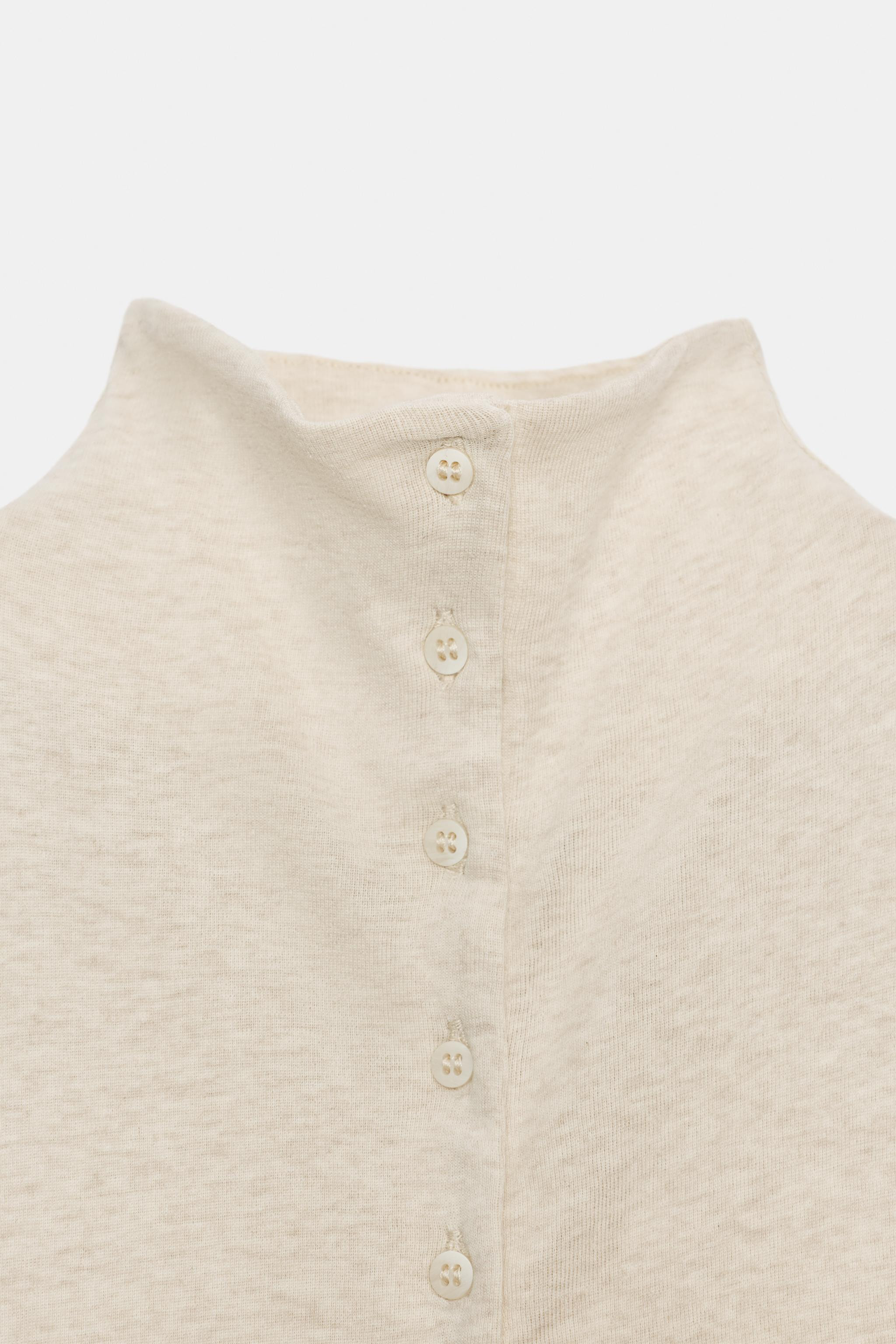 Top with main fabric made of cotton yarn. Mock neck and sleeveless design. Straight hem. Front bu... | Zara US