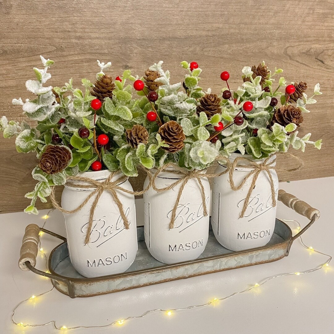 Add rustic winter charm to your home with this beautiful handcrafted arrangement by DesignedArrangements. Featuring three white jars filled with glittery eucalyptus, red berries, and mini pinecones, all set in a galvanized metal tray, this piece perfectly captures the cozy magic of the season. Each arrangement is handmade with high-quality, realistic materials—ideal for your mantel, dining table, or entryway display. ❄️❤️✨

#WinterDecor #ChristmasCenterpiece #EtsyFinds #HolidayHome #RusticChristmas #FestiveStyle #HandmadeDecor #FarmhouseHoliday #WinterArrangement #DesignedArrangements

#LTKSeasonal #LTKFindsUnder50 #LTKHome