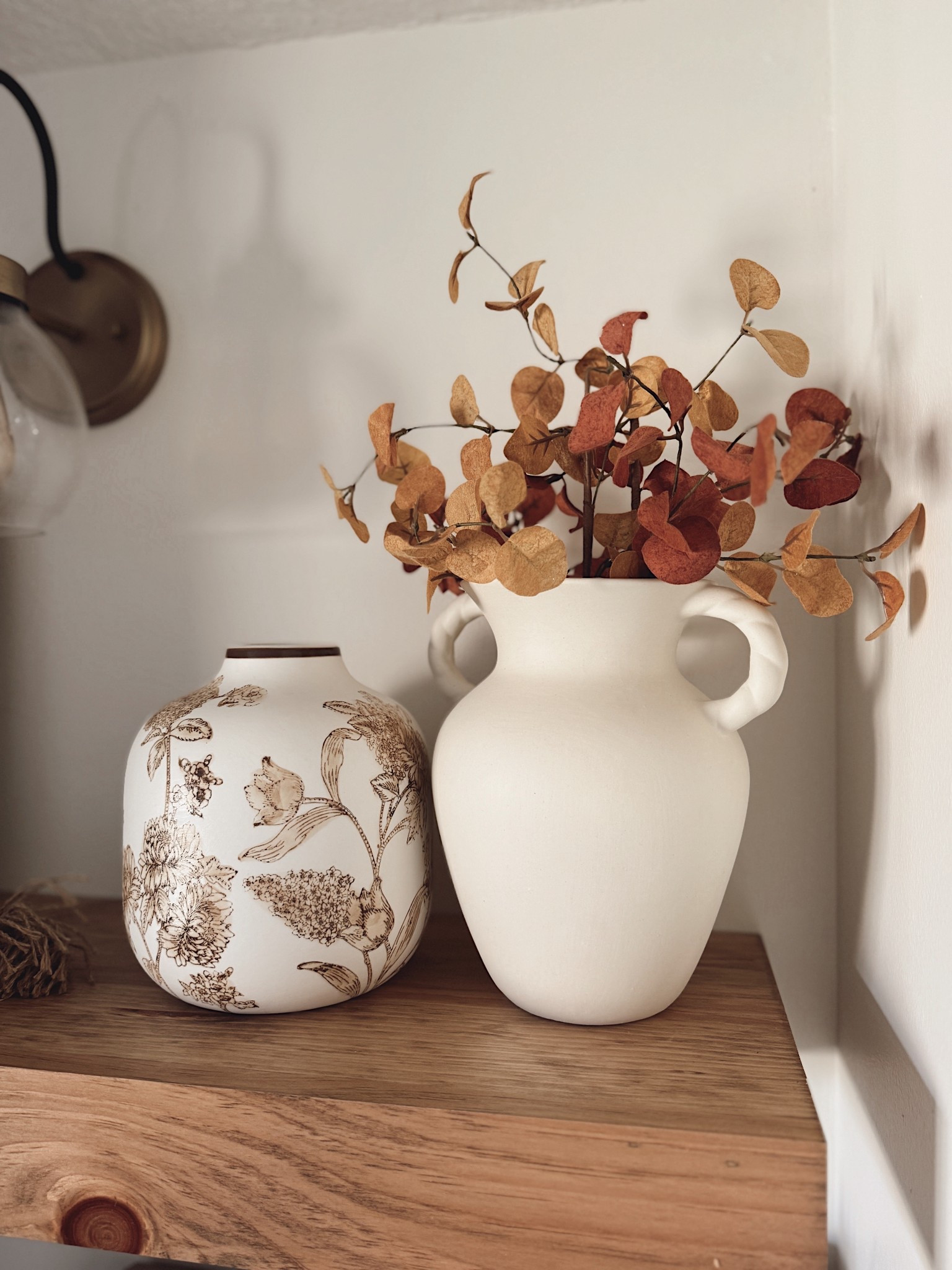 Shelf styling made simple 🍂✨ I love mixing textures like this neutral ceramic vase with warm faux stems next to a patterned floral vase. It adds just enough interest while still keeping a clean + cozy look. 

#ltkhome #shelfdecor #neutraldecor #fallhomedecor #ltkfinds #homestyling
