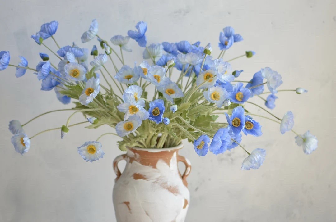 Bright, cheerful, and forever in bloom 💙 These blue faux poppy flowers are an easy way to capture that fun spring-to-summer poppy look without worrying about wilting. Crafted from fabric silk with soft flocked stems, each 23.5” fully wired stem can be bent or trimmed to fit your craft vision perfectly. Ideal for DIY arrangements, seasonal décor, or statement vases, these poppies add a pop of color you can enjoy year-round.

#LTKhome #LTKcrafts #LTKdecor #fauxflowers #silkflowers #poppies #springdecor #summerdecor #craftsupplies

#LTKSeasonal #LTKHome #LTKWedding