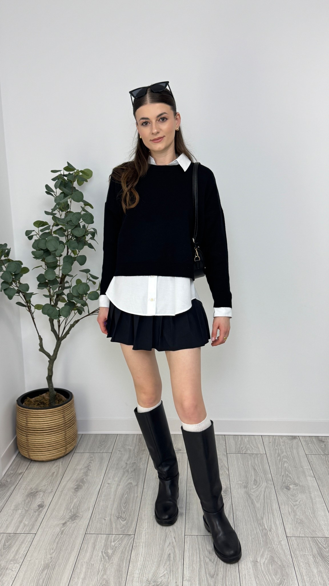 A black jumper over a crisp white shirt pairs effortlessly with a pleated mini skirt. Knee-high boots and bambi leg warmers add a trendy touch, while a structured bag completes the look 🖤 #IlaStylesDiary 

#LTKspring #LTKeurope #LTKworkwear