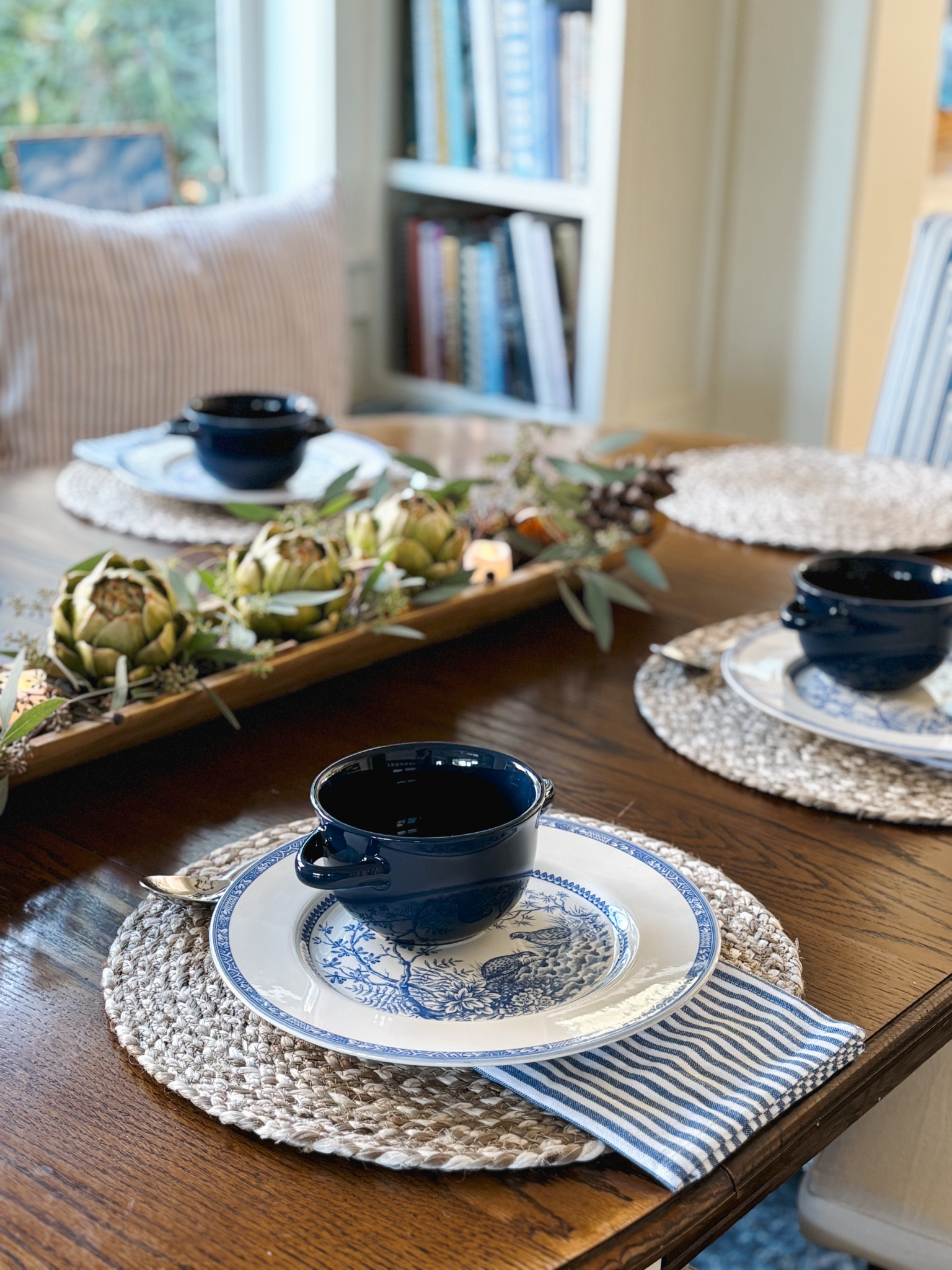 Two handled bowls, blue and white plates, striped napkins, woven placemat chargers, wood bowl 

#LTKSeasonal #LTKHome #LTKStyleTip