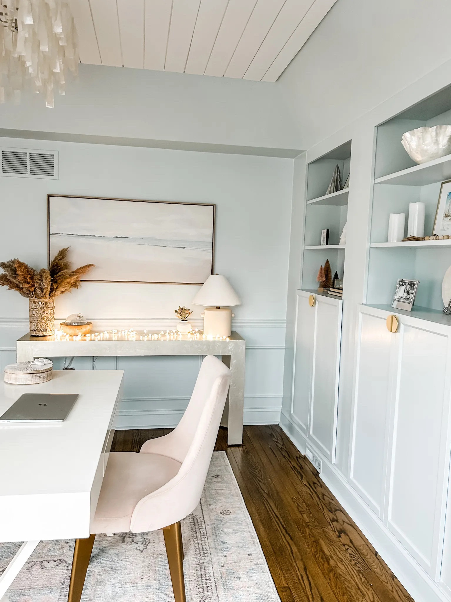 Coastal home office, blush area rug, capiz chandelier, coastal chandelier, shell chandelier, wall art, framed canvas wall art, landscape wall art, neutral wall art, shelf decor, white x-crossed legs desk with drawer, neutral decor, blush velvet desk chair, pampas grass, ceramic table lamp, Studio MCGee table lamp, brass hardware, gold half circle pulls. Desk decor. Target. West Elm.

#LTKstyletip #LTKhome #LTKFind