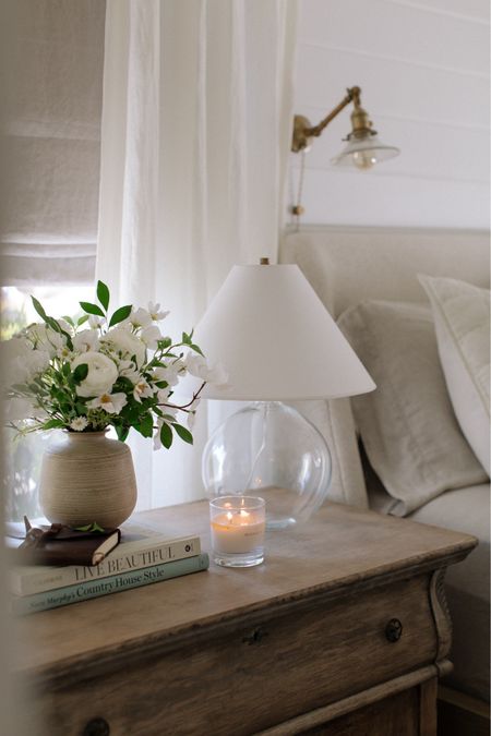 bedside, nightstand things, glass lamp, cozy candle, faux florals, Roman shades & linen curtains 

#LTKSpringSale #LTKhome