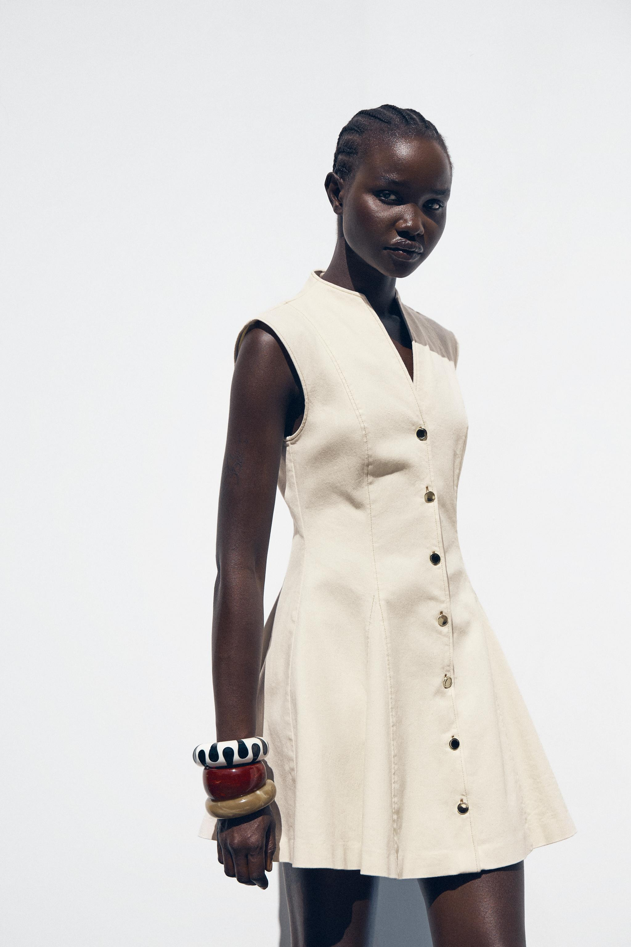 Round neck dress with a V-neck. Sleeveless. Flared hem. Fabric detail with contrasting topstitchi... | Zara US