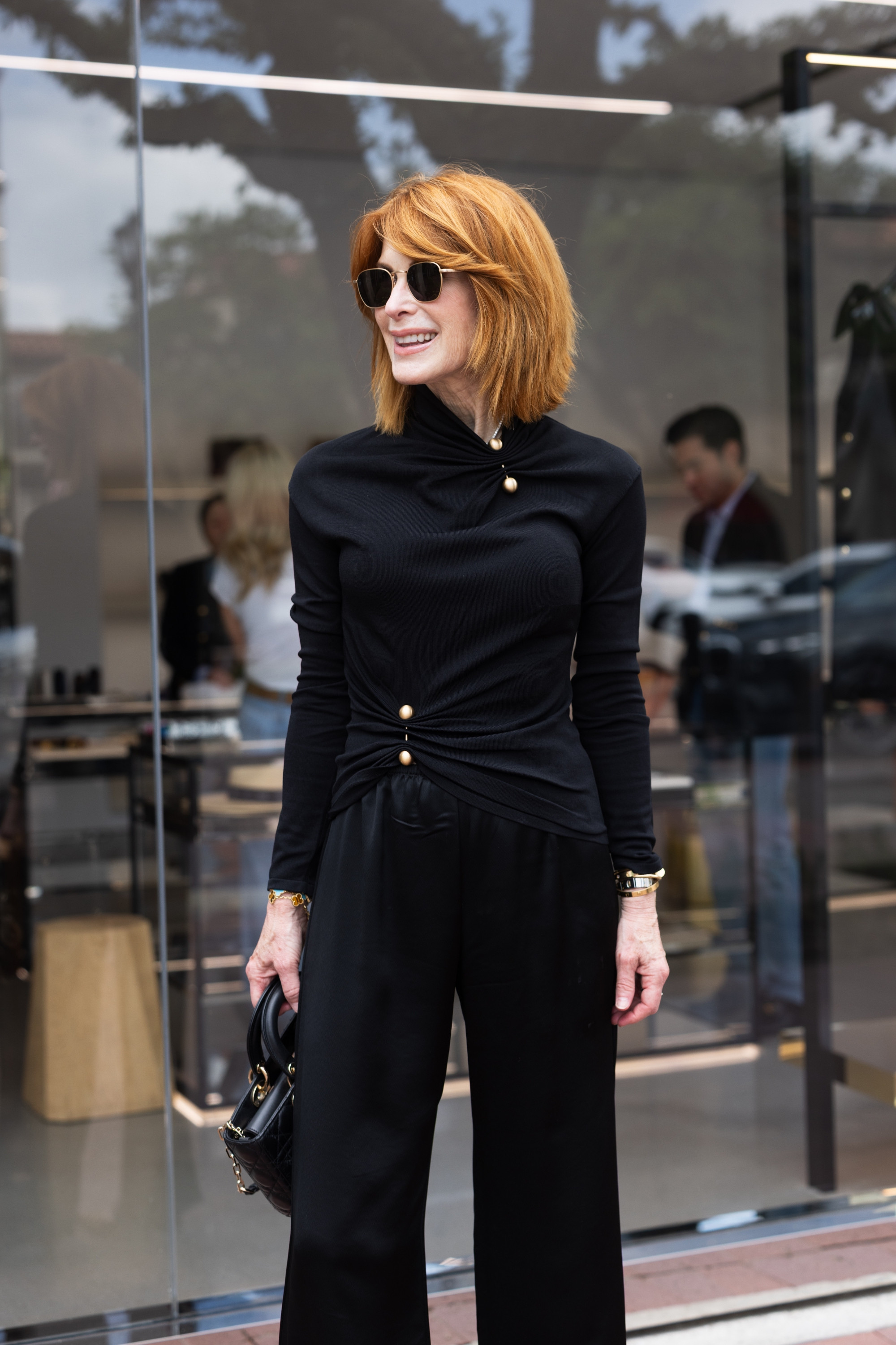 This black Cult Gaia top is such a chic statement piece for fall outfits women over 50 can wear now. I love the gold button detail with relaxed black pants and leopard heels for date night outfits or elevated work outfits. #LTKOver40 #FallOutfits #DateNightOutfits #WorkOutfits #BusinessCasualWorkwear 

 #LTKootd #LTKSeasonal #LTKOver40