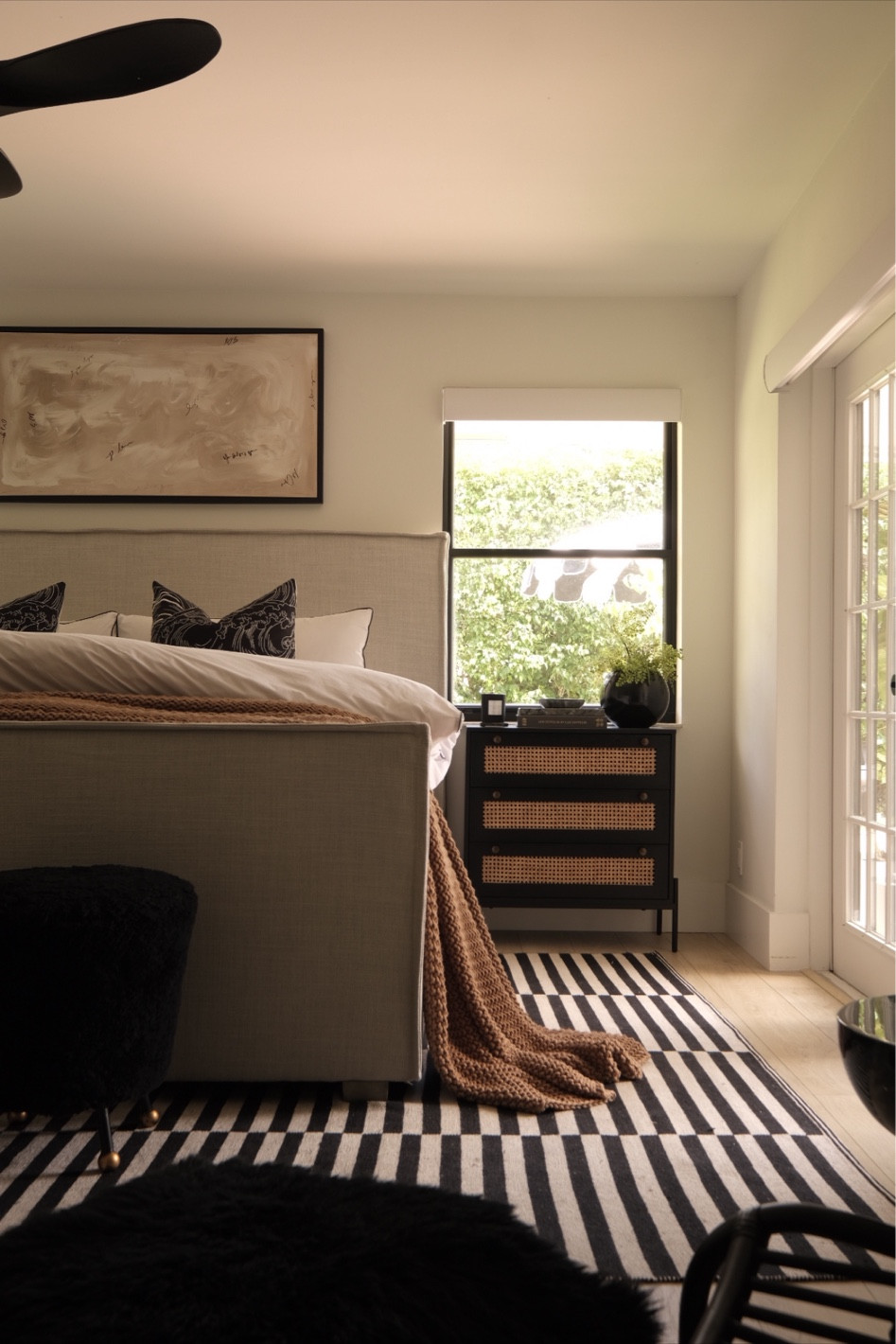 Primary bedroom decor. 
Upholstered bed. 
Black nightstand. 
Striped rug. 
#meandmrjones 

#LTKhome #LTKunder50 #LTKunder100