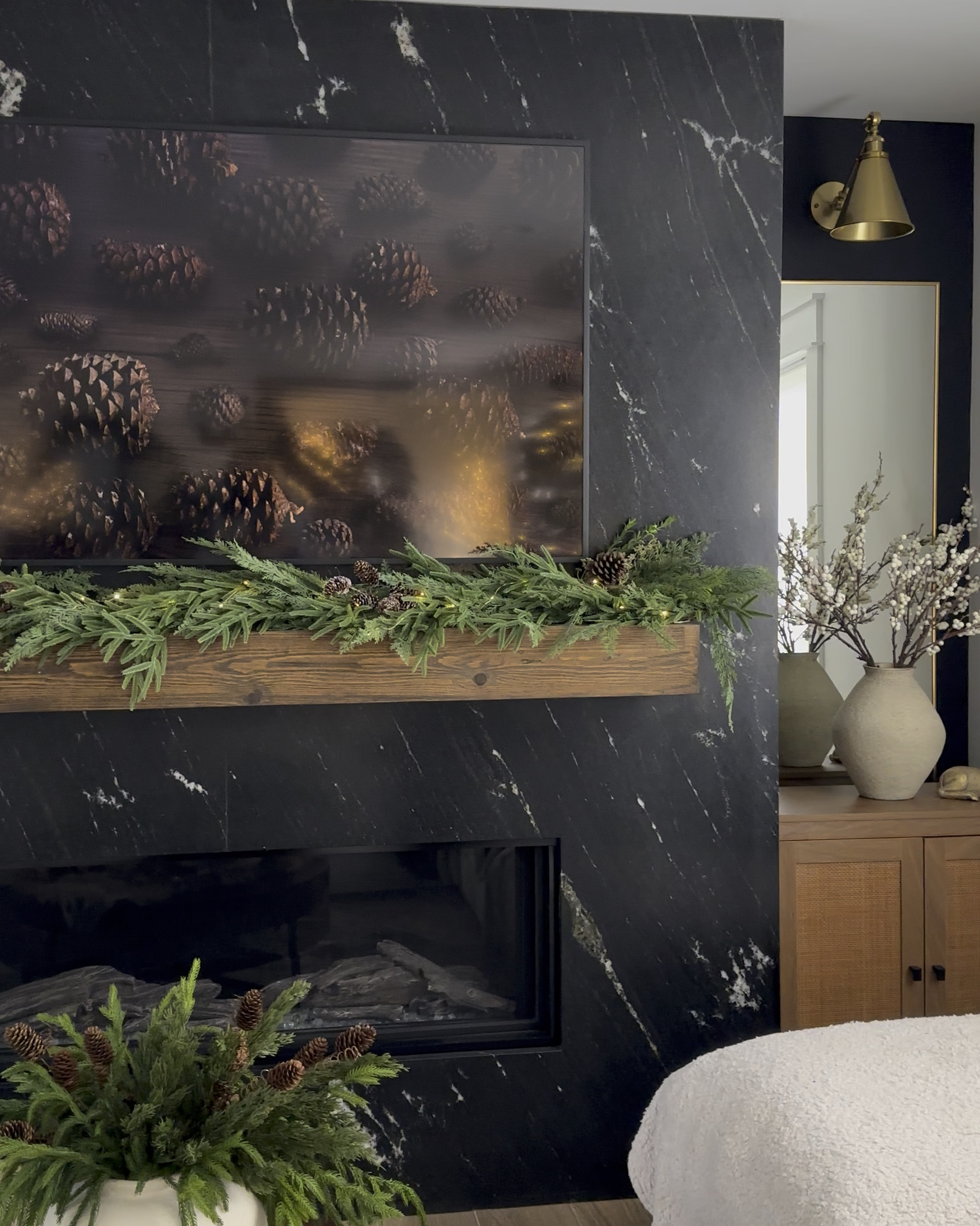 I decide to create a woodsy organic look again this year The mixed pine garland is brand new and it’s absolutely amazing! It’s very full with rich green colors and the combination of cypress cedar and Norfolk pine is perfection! I draped it to one side for a modern look and added pinecone stems to give it that earthy vibe. I finished with rustic gold bells and beautiful brown satin bow. 

Here’s what I used:
Mixed pine garland
Twig pine and Myrtle branch with pinecone
pinecone stems
gold rustic bells
fairy lights
brown satin ribbon
thin nails
command hook

The style edit collective
The Hillary style
Amazon finds


#LTKHome #LTKHoliday