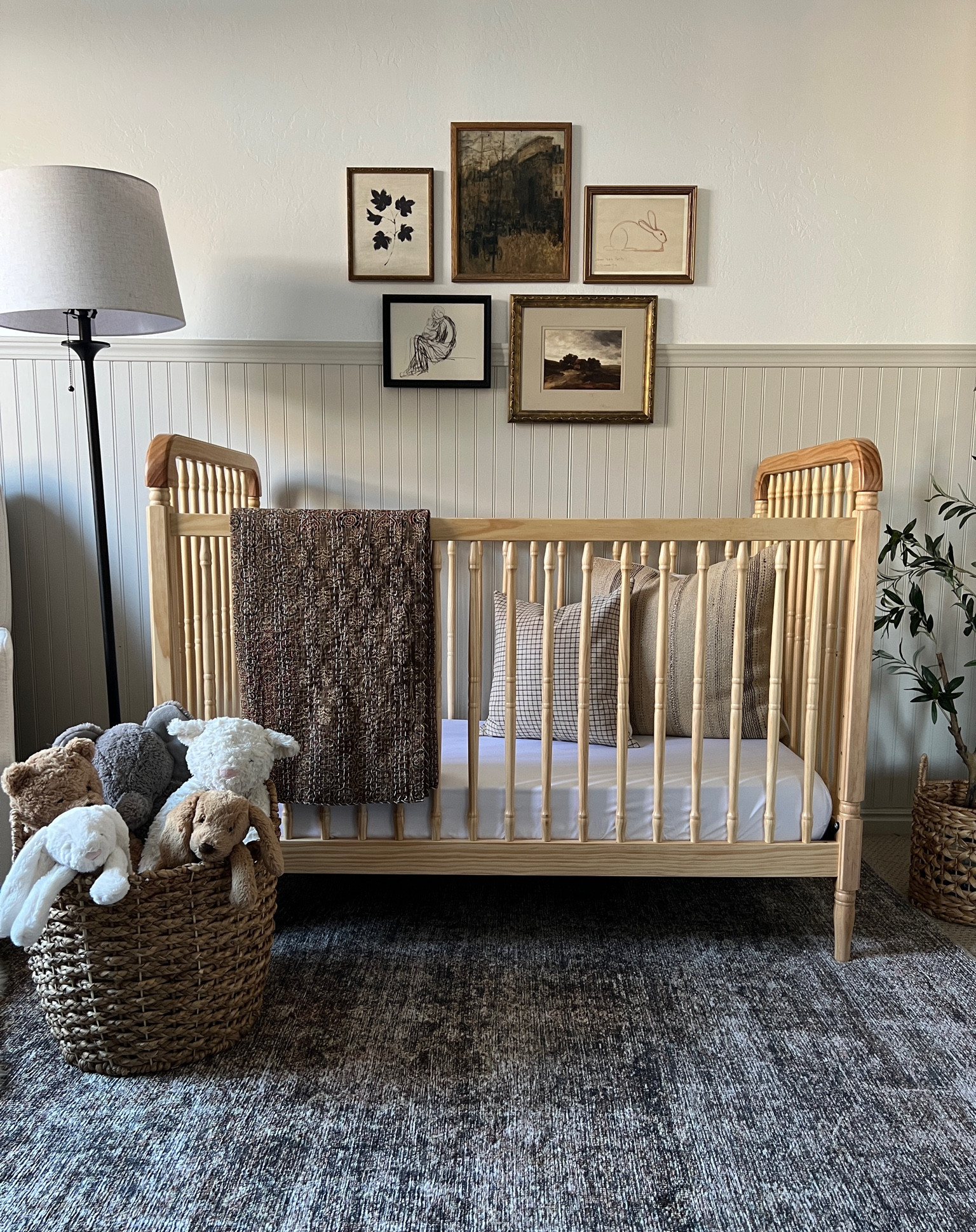 Neutral nursery styling 

Neutral spindle crib light natural wood upholstered glider white fabric check plaid throw pillow cover dark beige kilim stripe tan ivory pillow cover brown kantha quilt vintage framed art landscape vintage city brown rug Jellycat stuffed bunny doggy plaid drapery curtains vintage aged brass rocking horse arched mirror vintage childs chair iron floor lamp small faux tree pleated lamp shade floral black fabric kids woven rush seat chair vintage brass horse 

#LTKhome #LTKunder100 #LTKFind