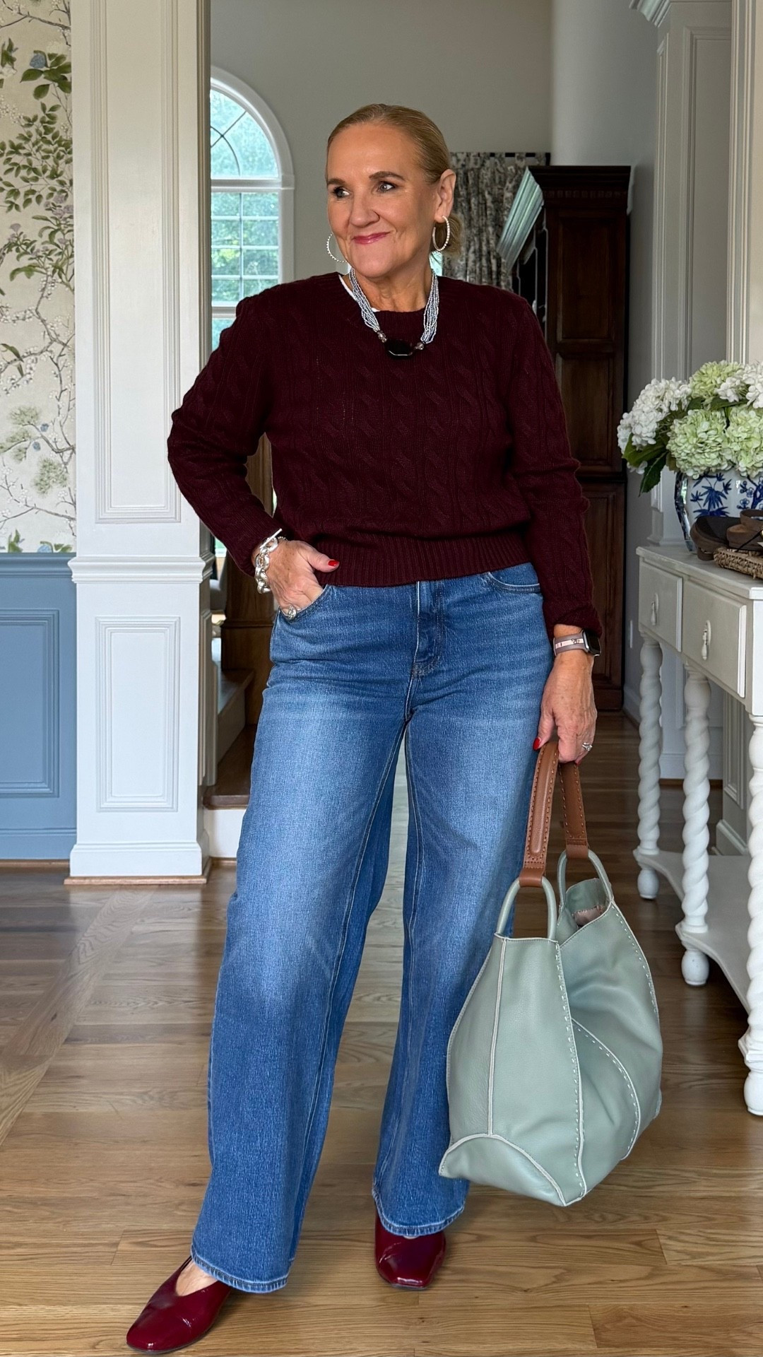 Gotta say, this burgundy cable-knit cashmere sweater is a beauty! I’m wearing a large, and I like how the classic jeans and unexpected pale blue bag make the whole outfit feel fresh.