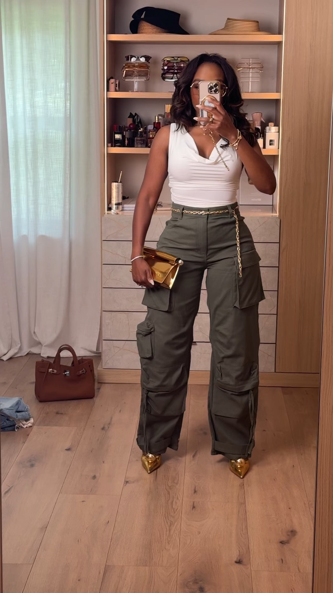 Hi Babes! 🤍💚

Cargo pants are still having a major moment, and I love how these olive green cargos instantly elevate a simple white tank. The gold accessories and pointed heels take this look from casual to chic in seconds.

✨ Fit Details:
• Flattering draped white tank
• High-waisted cargo pants
• Relaxed wide-leg fit
• Functional cargo pockets
• Comfortable with an elevated feel

💫 Where To Wear:
• Concerts
• Girls' night out
• Casual dinners
• Weekend brunch
• Date night
• Travel days

👜 Accessories:
• Gold clutch
• Gold statement heels
• Layered jewelry
• Chain belt detail

The perfect balance of edgy, feminine, and effortlessly cool.

Everything is linked below!

xx Kira | IG: KirasFashionFinds

📏 Measurements: 5'4" | 140 lbs | 34D Bust | 27" Waist | 40" Hips