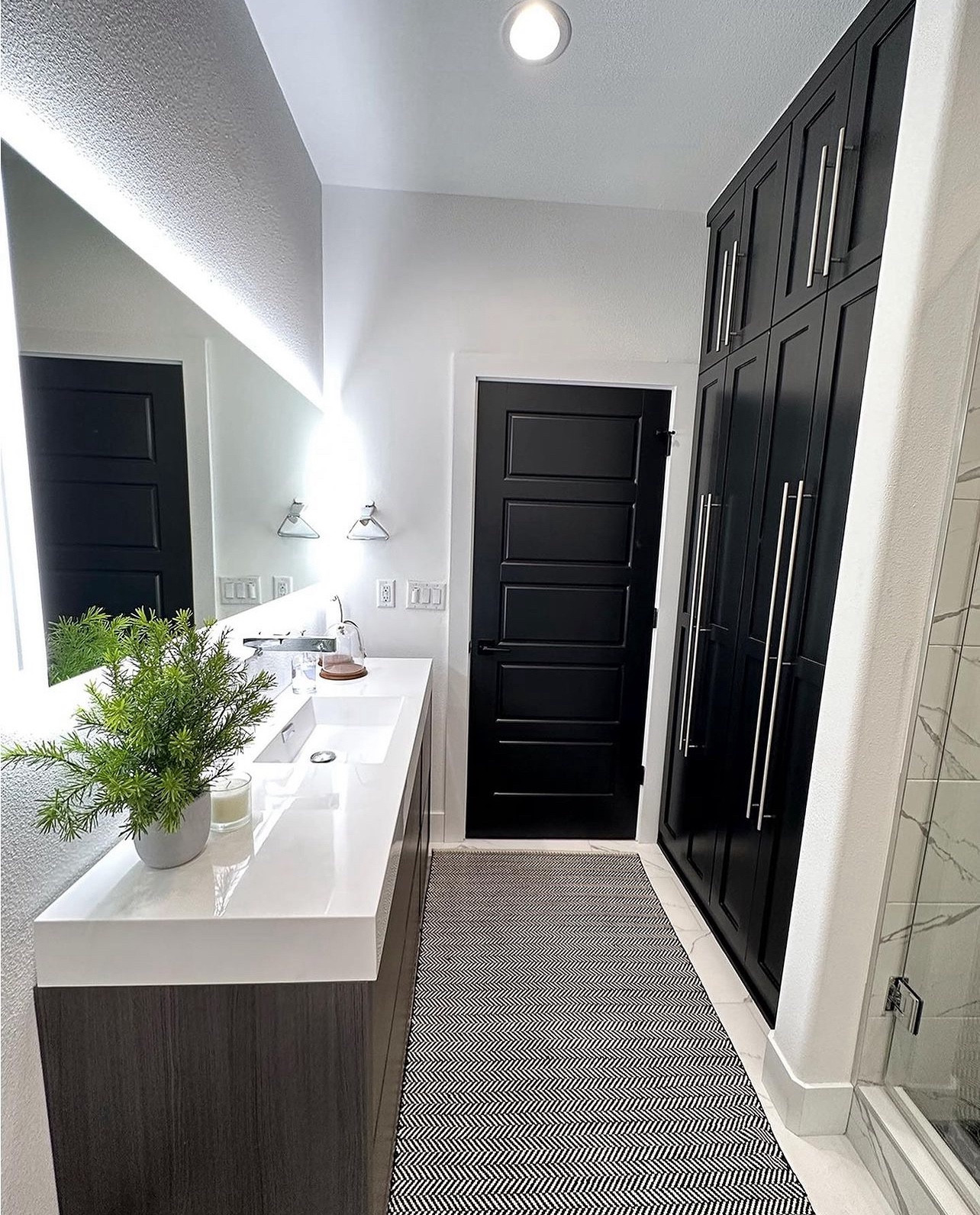 Neutral colors and spa like feel make this guest bath the perfect retreat at the end of the day. Loving this warm twist on black and white design  

Modern bathroom, linen cabinet, white countertop, lit mirror, black and white rug

#LTKhome