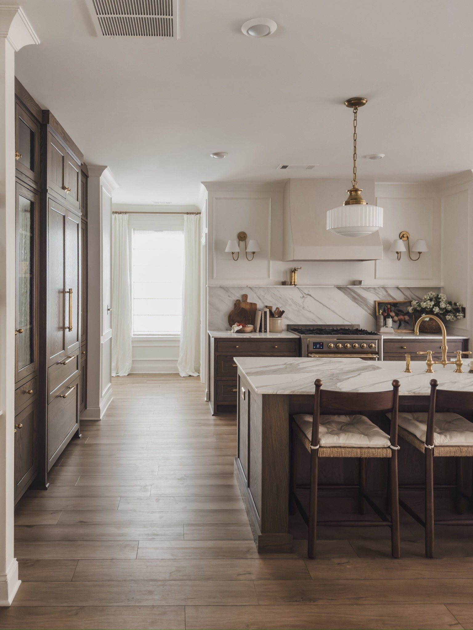Timeless, open concept kitchen views with rich wood tones, creamy whites, and unlacquered brass details. When styling this space I opted to keep the island as a clean slate to let the marble speak for itself, truly so stunning!

Home finds, neutral home inspo, timeless kitchen views, collected style, furniture favorites, counter stool, pendant lights, milk glass pendant, unlacquered brass detail, wall sconces, faux florals, linen curtain, linen detail, roman shades, cutting board, rich wood tones, Home and Kids Co, Wayfair, McGee and Co, Rejuvenation, found it on Amazon, shop the look!

#LTKHome #LTKSeasonal
