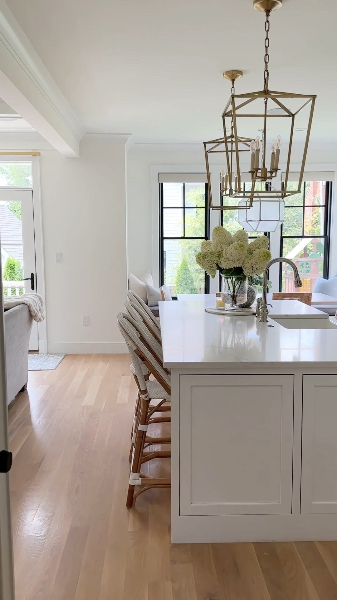White kitchen, brass lanterns, kitchen island lighting, white woven rattan bistro counter stools, coastal home, kitchen island styling, farmhouse sink, kitchen faucet, mixed metals, coastal home decor 

#LTKFind #LTKstyletip #LTKhome
