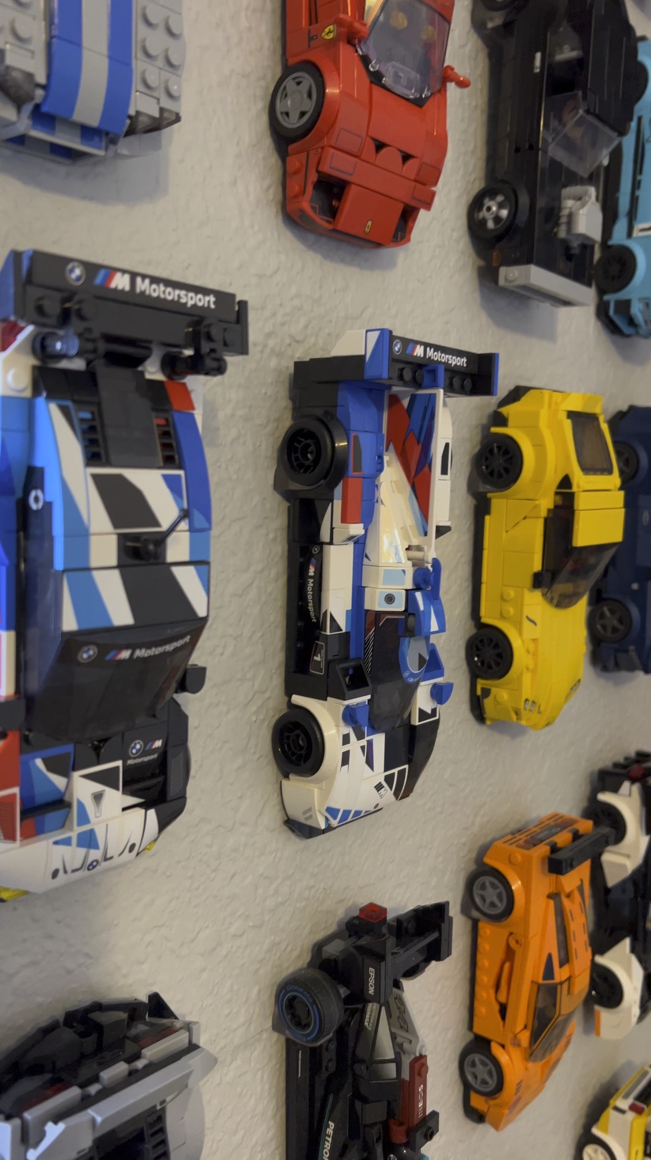 Lego speed champion wall mounts. The first one linked is the set he has but they’re currently unavailable in clear so I’ve linked a few others that are similar!
