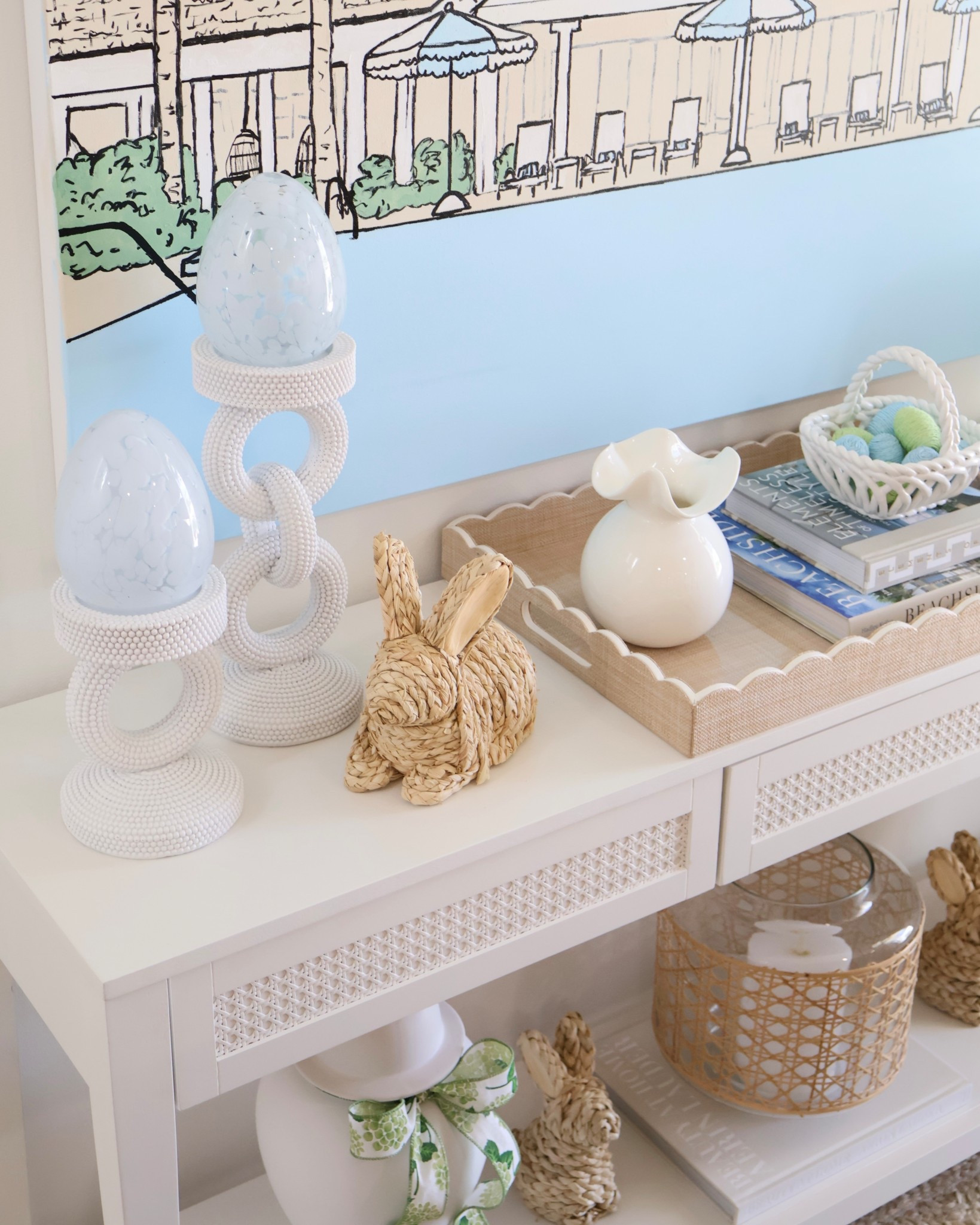 Seasonal Spring styling with some of my favorite Easter home decor finds 🩵🐰 I added these beautiful light blue glass eggs from Marshalls to my console table for an easy coastal Easter decor look. Paired with woven bunny decor, neutral spring home accents, and white decorative candlesticks, this creates a soft blue and white Easter aesthetic that feels perfect for a coastal grandmother / Serena & Lily inspired home.

If you’re looking for affordable Easter decorating ideas, this look mixes budget friendly Easter decor, neutral spring decorations, woven bunny figurines, decorative Easter eggs, and light blue spring accents to create a fresh spring entry table or console table styling moment.

Perfect for anyone searching for coastal Easter decor, blue and white spring decor, woven bunny decor, Easter console table styling, neutral Easter home decor, affordable Easter decorations, Marshalls home finds, and spring home styling ideas.

✨ Shop these Easter decor finds, glass decorative eggs, woven bunnies, scalloped tray decor, and neutral spring accents linked here.

@Marshalls 

#LTKHome #LTKSeasonal