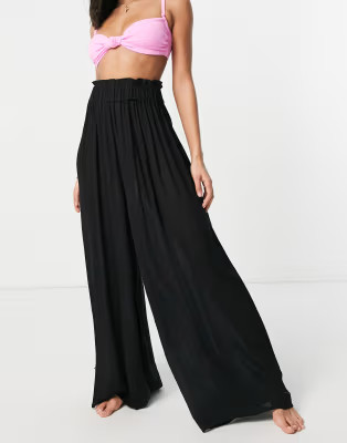 ASOS DESIGN crinkle wide leg palazzo beach pants in black | ASOS (Global)