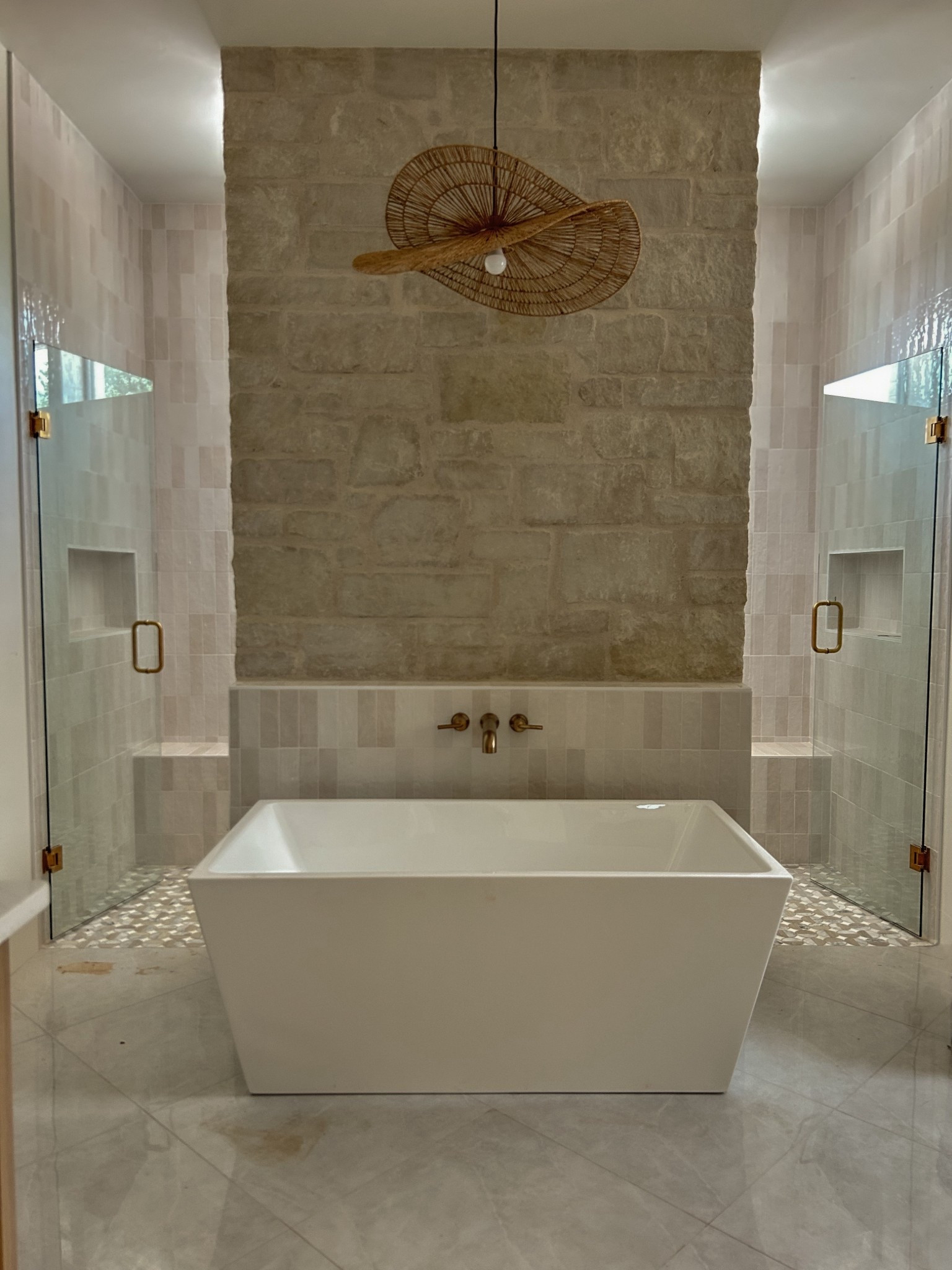 A sculptural pendant makes this spa-like bathroom feel even more elevated.
I love using natural materials in modern spaces — this woven light fixture adds softness and movement above the clean lines of the tub and stone wall. Tap to shop the exact light and browse a few more favorites that bring warmth and texture to a bathroom.
