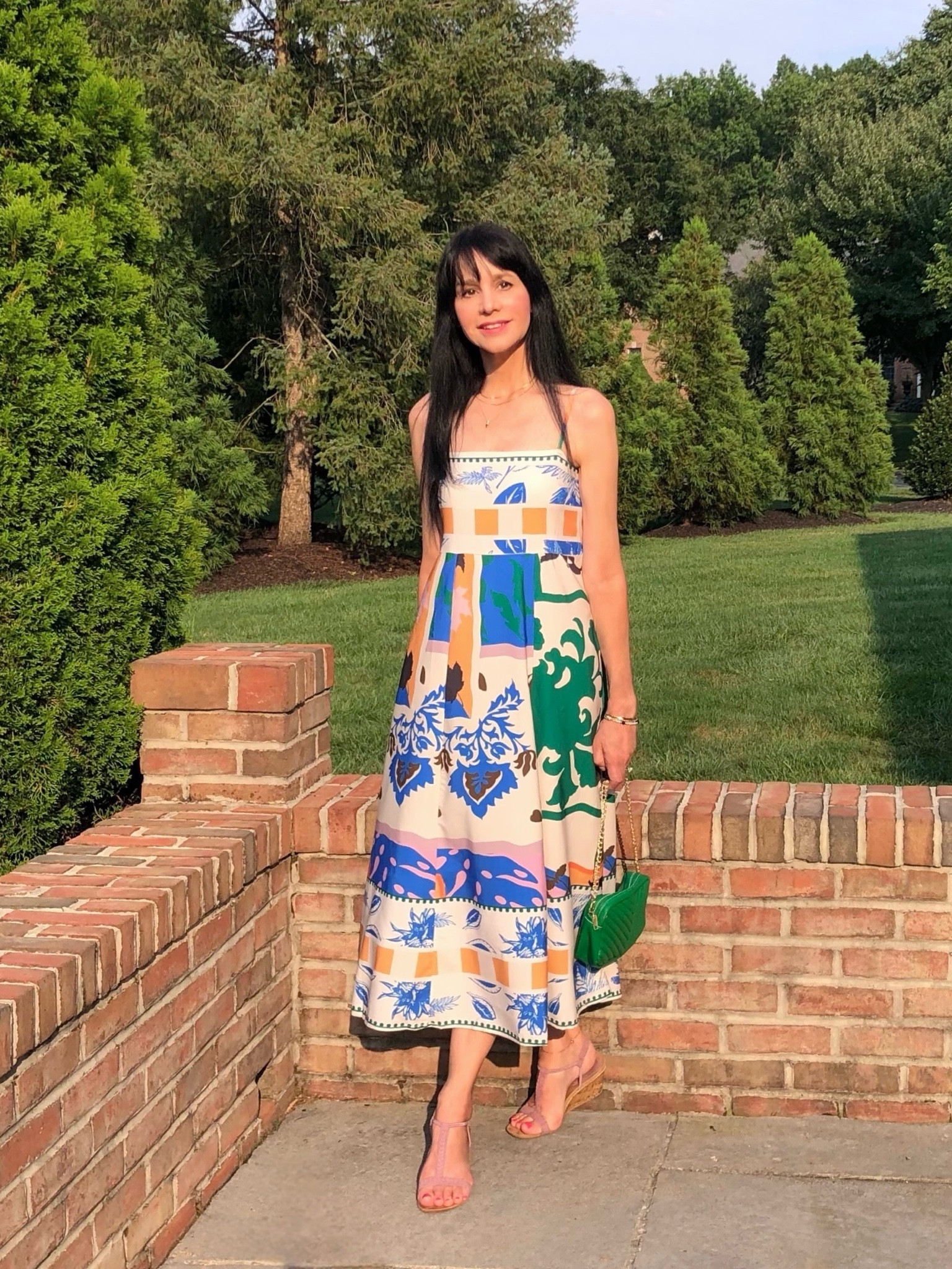 After a week of heavy rain, it was so wonderful to have a weekend of sun and no humidity! I am grateful, however, that the rain has restored the grass and foliage back to their rich green colors!

Wearing here one of the most popular dress styles this season! Usually I like more of a waist fit but this falls right between an empire and a true waist, giving some shape to it but with an extremely comfortable, nonrestrictive fit—so perfect for warm summer days and vacation sightseeing! I’m crazy about the tropical vacation vibe print! I love how comfortable this fit-style is so much that I bought it in 3 different dresses (I posted one variation on 7/16 and will post the 3rd soon).
Accessorized with a cute green chain strap bag to pick up the green in the dress and lavender wedge sandals to pick up the splashes of lavender.
