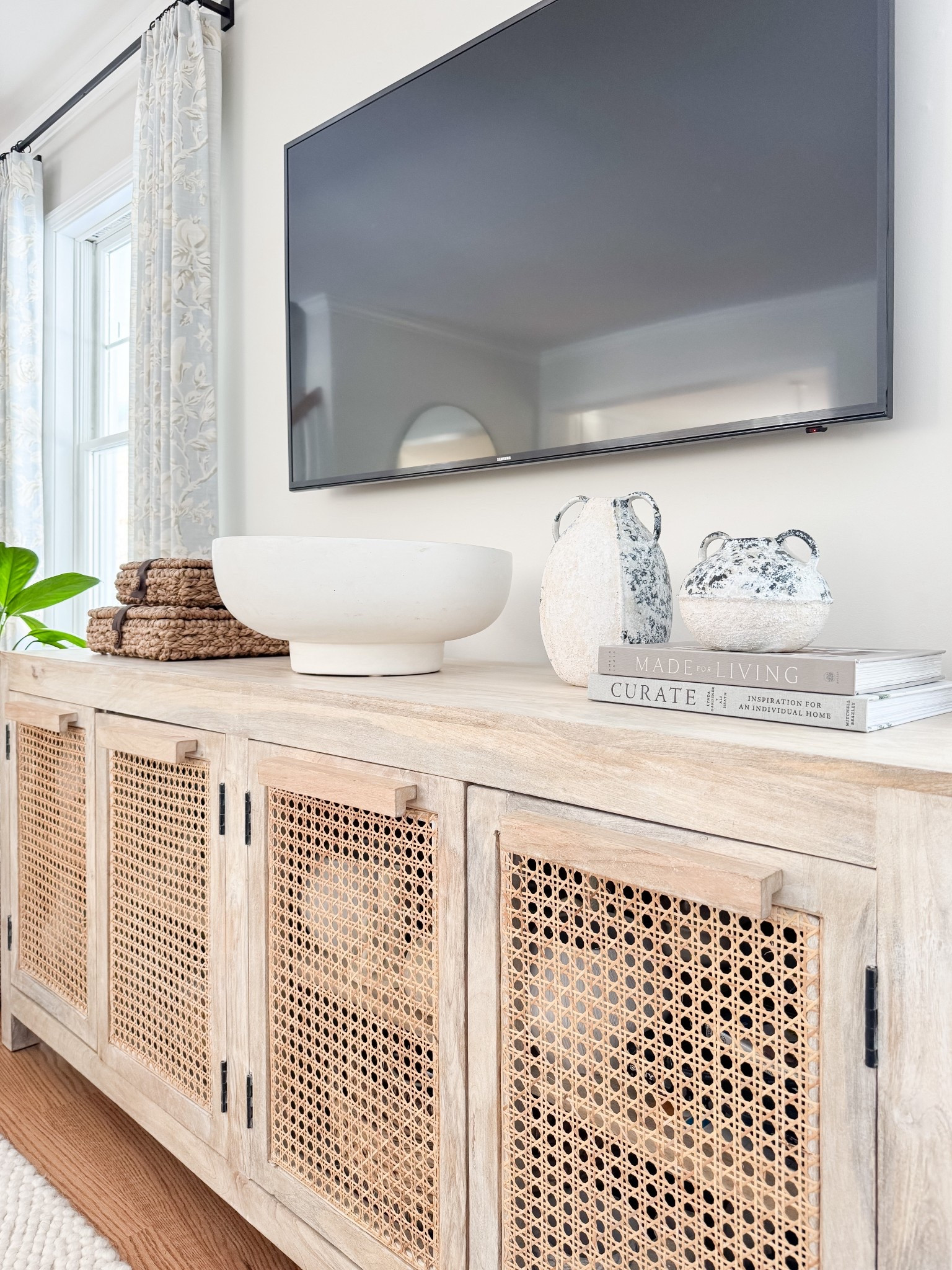 Media console styling! A neutral living room styled with a warm wood console, textured decor, and simple coastal accents. Neutral media console, coastal living room decor, warm wood furniture, cane cabinet styling, coastal neutral home, timeless living room design, Sherri calnan home

#LTKHome